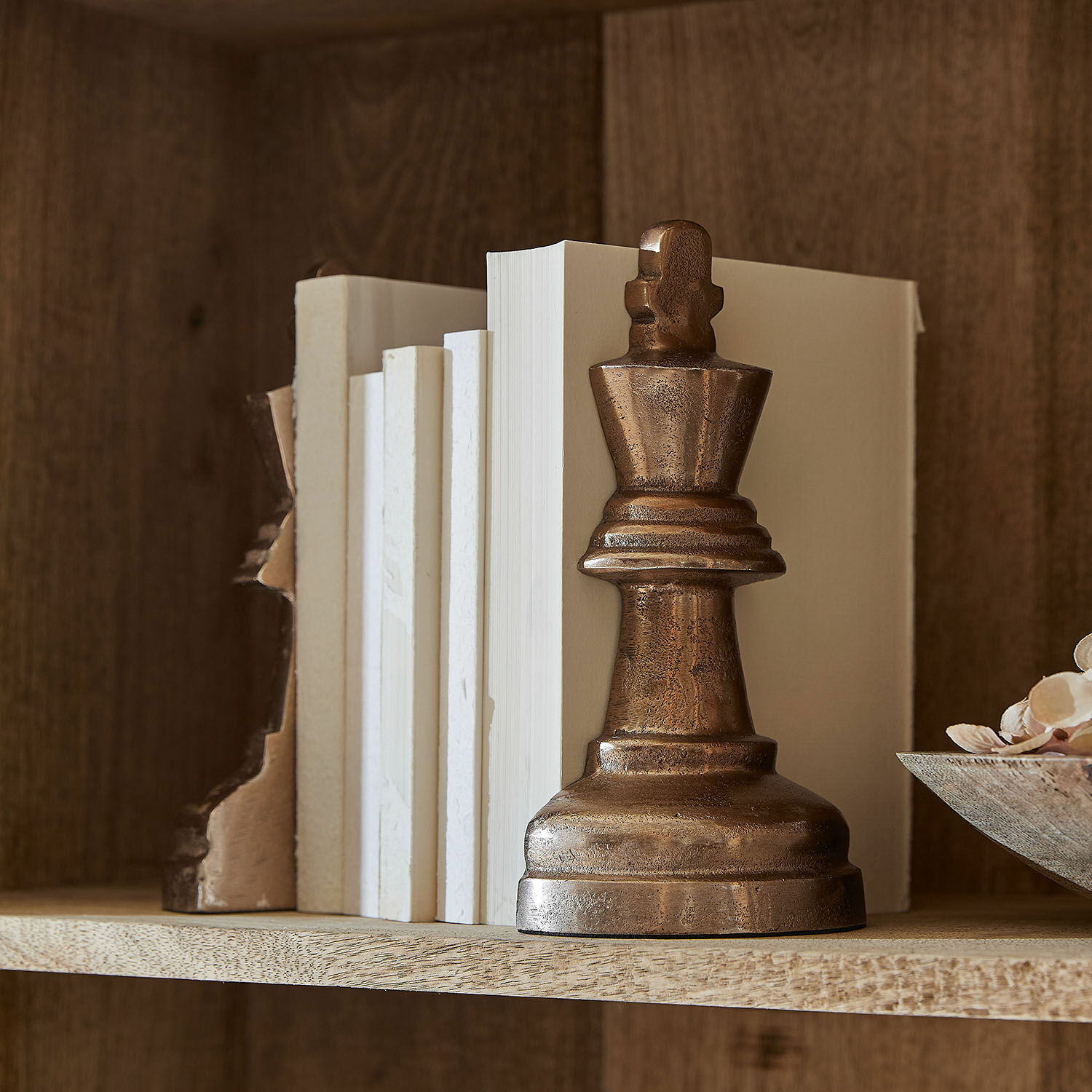 Boekensteun set van 2 Raffinique Metalen boekensteun in koperen kleur in de vorm van een schaakkoning op een houten plank met witte boeken