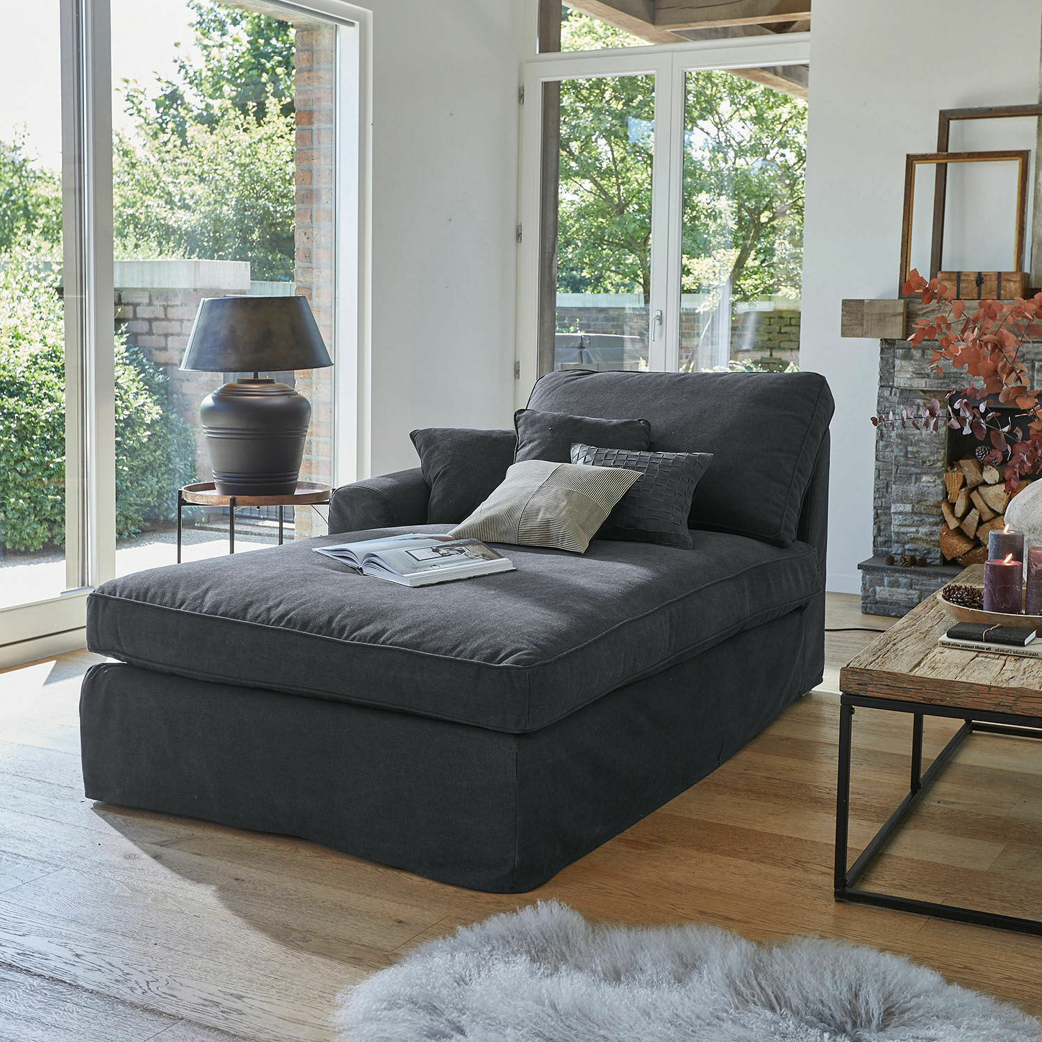 Chaise longue Seaford Donkergrijze gestoffeerde chaise longue met kussens in moderne woonkamer met houten vloer