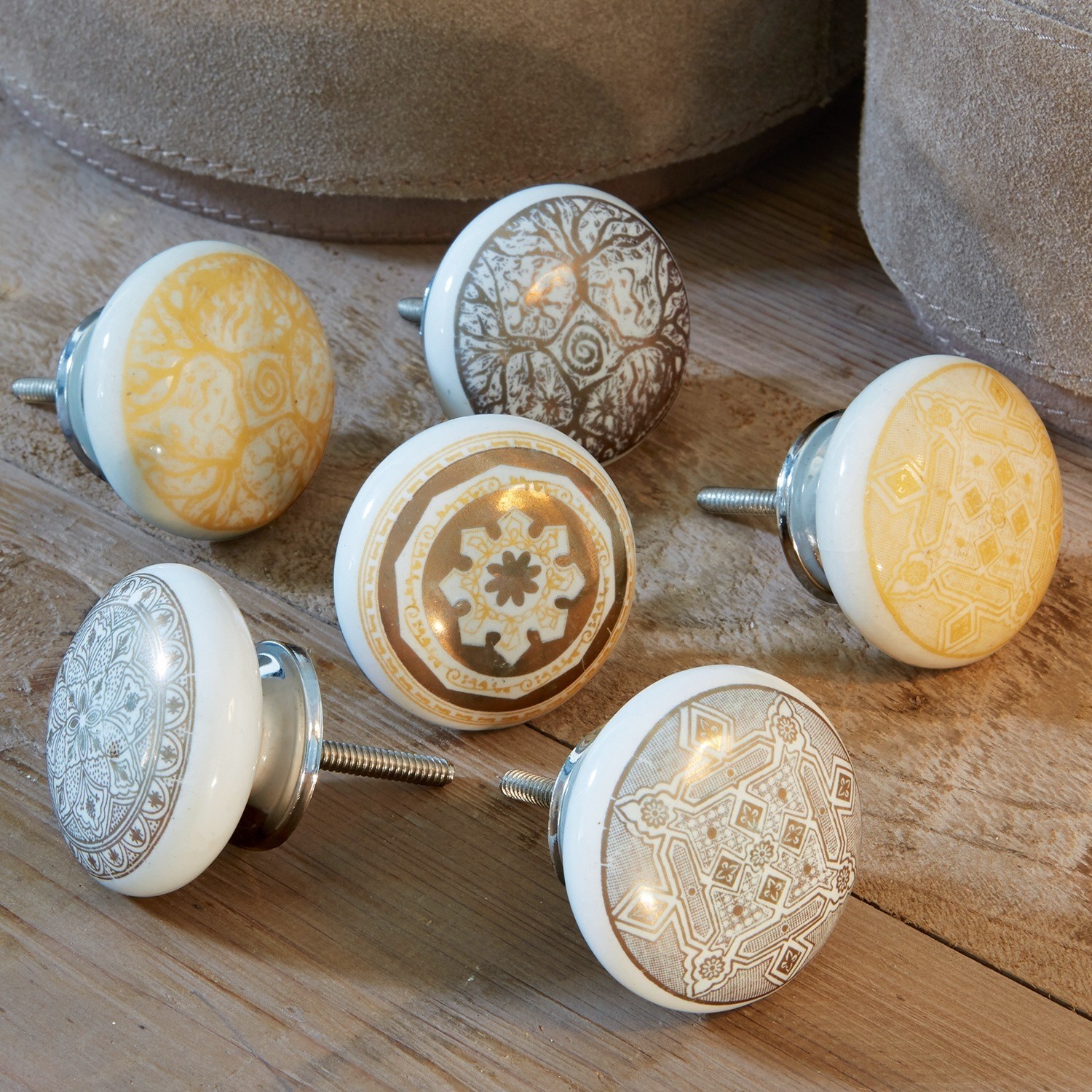 Set van zes keramische meubelknoppen met bruine en beige patronen op houten achtergrond