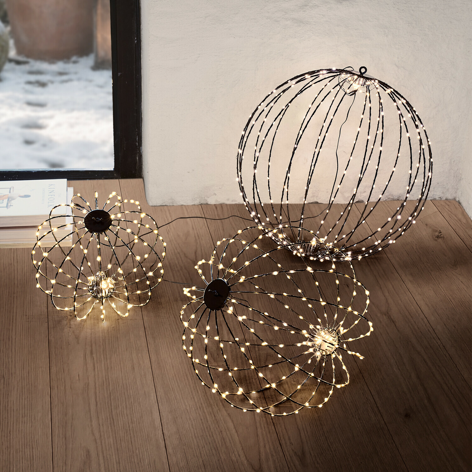 Twee decoratieve LED-lichtbollen in warm wit op de vloer van een moderne woonkamer