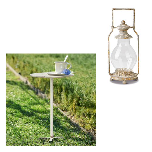 Lichte metalen tuintafel met kopje en bloem op gras, tuinmeubilair