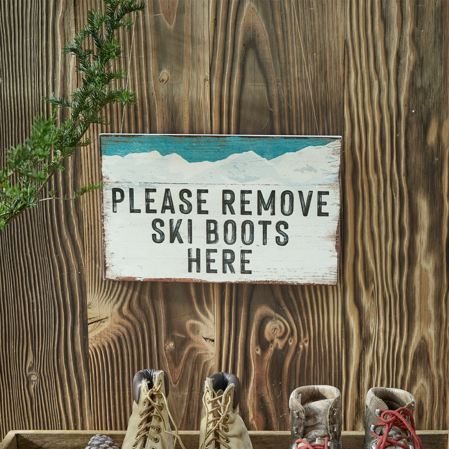 Decoboard Uptonvale Houten bord met tekst om skischoenen uit te doen, met skischoenen voor een houten muur.