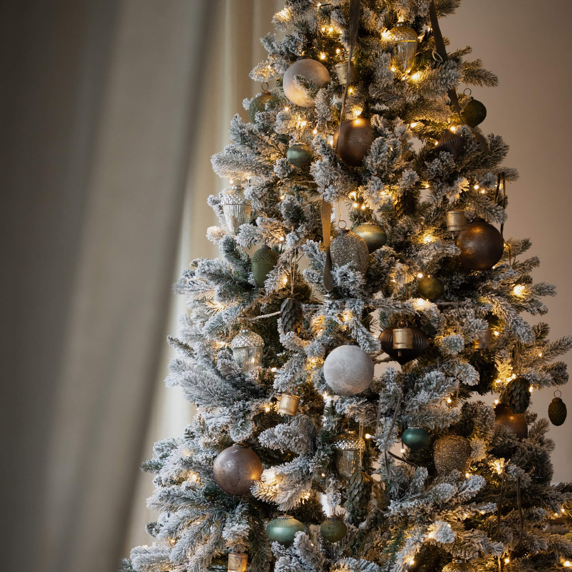 Kunstkerstboom met wit sneeuw-effect en gouden en groene versieringen, feestelijke decoratie