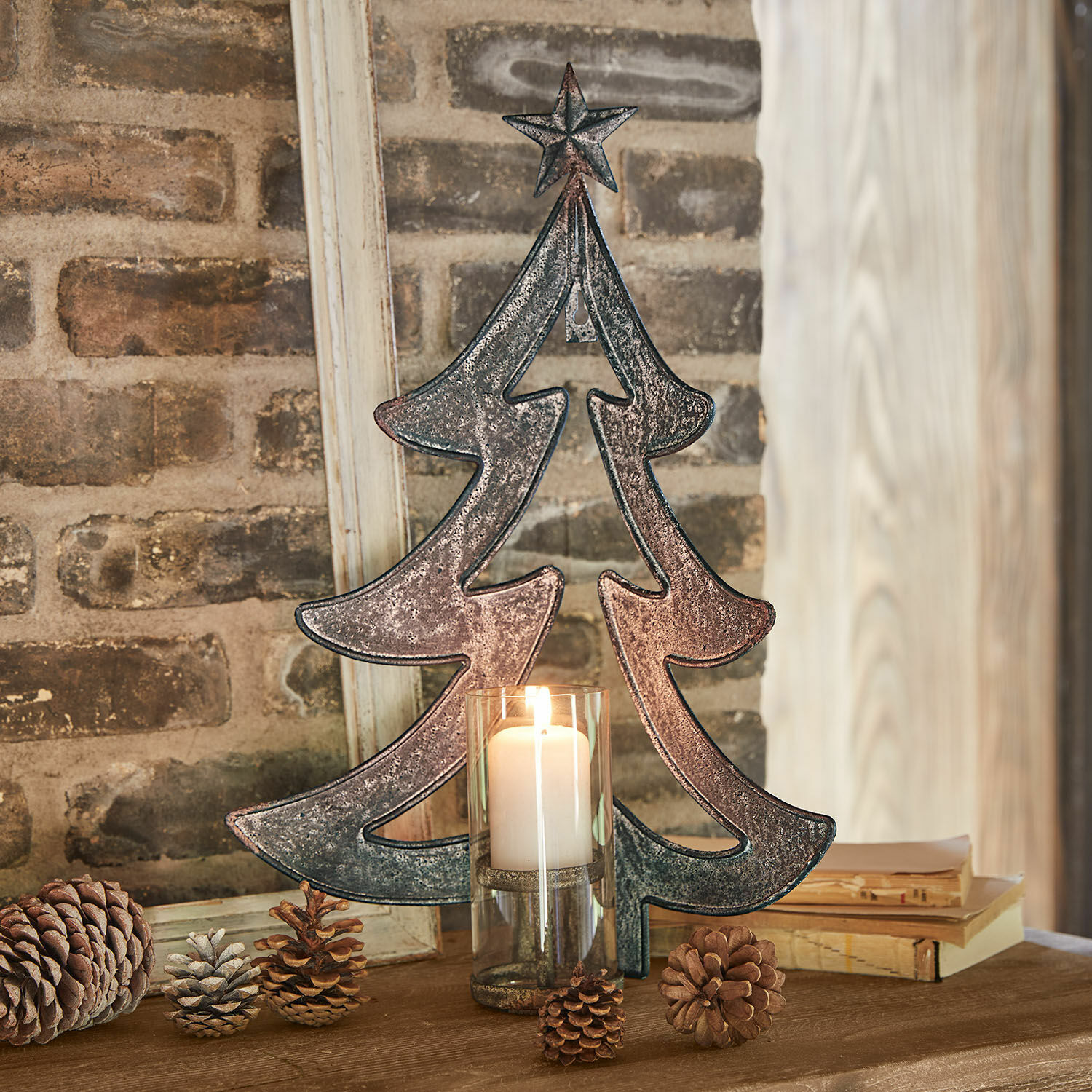 Wandkaarsenhouder Jolise Metalen kerstboomdecoratie met ster en kaars in glazen houder op houten tafel met dennenappels