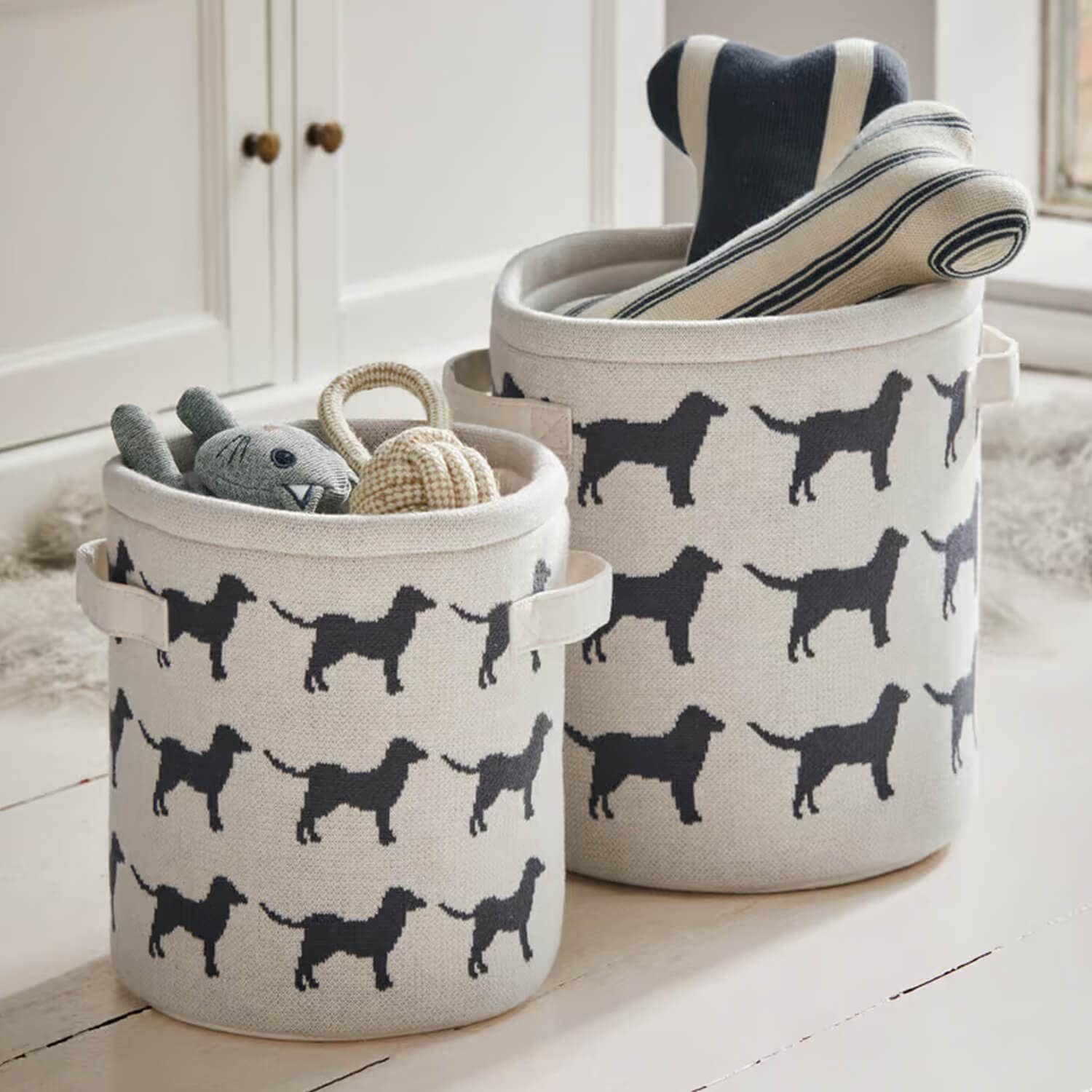 Beige katoenen manden met zwart hondenpatroon, ideaal voor het opbergen van speelgoed en accessoires.