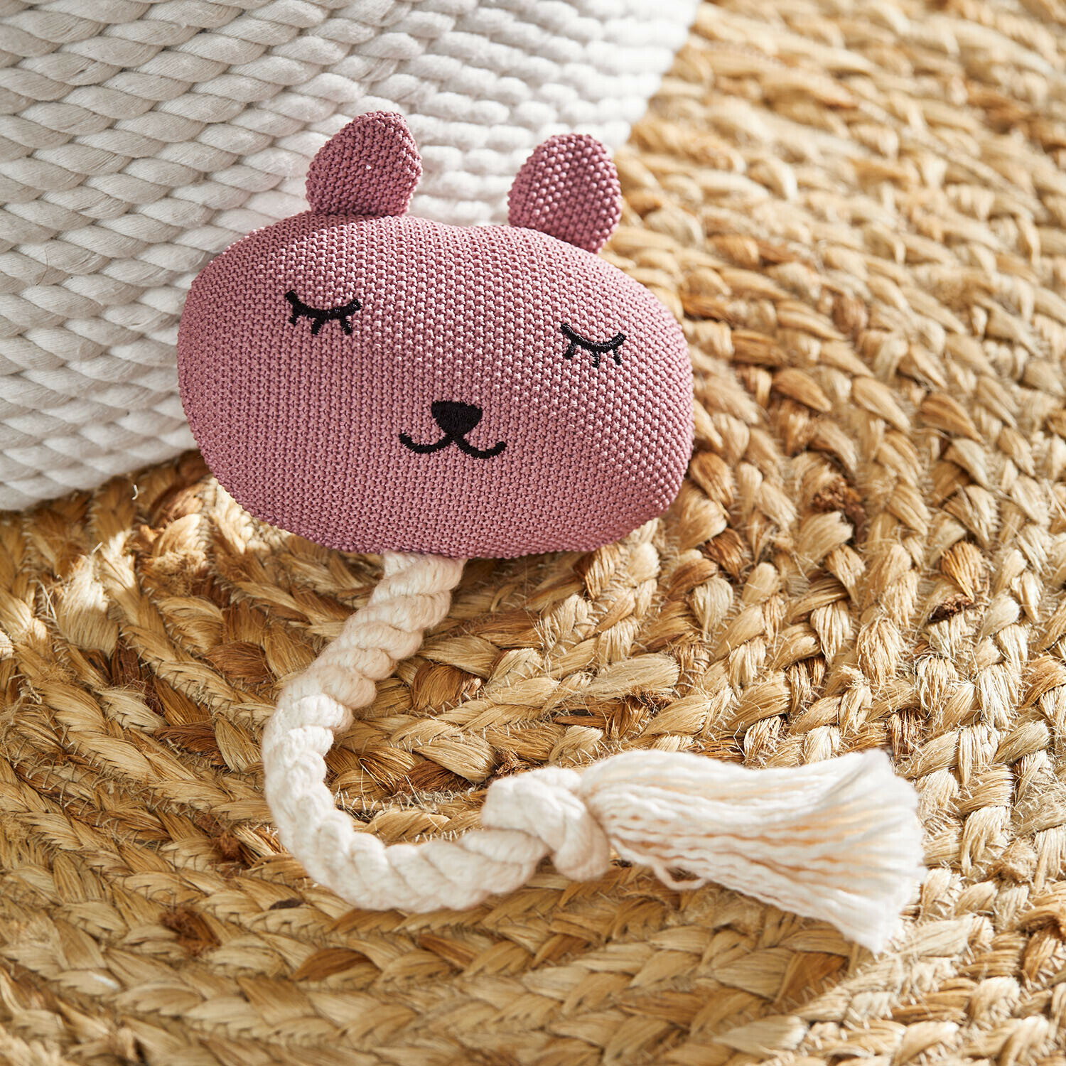 Huisdierenspeeltje Miezmo Roze gebreid dierenspeelgoed met wit touw op een gevlochten natuurlijke vloerkleed