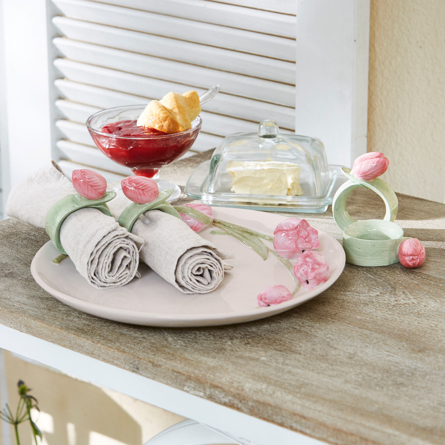 Keramische servetringen met roze bloemen op beige bord op houten tafel geplaatst