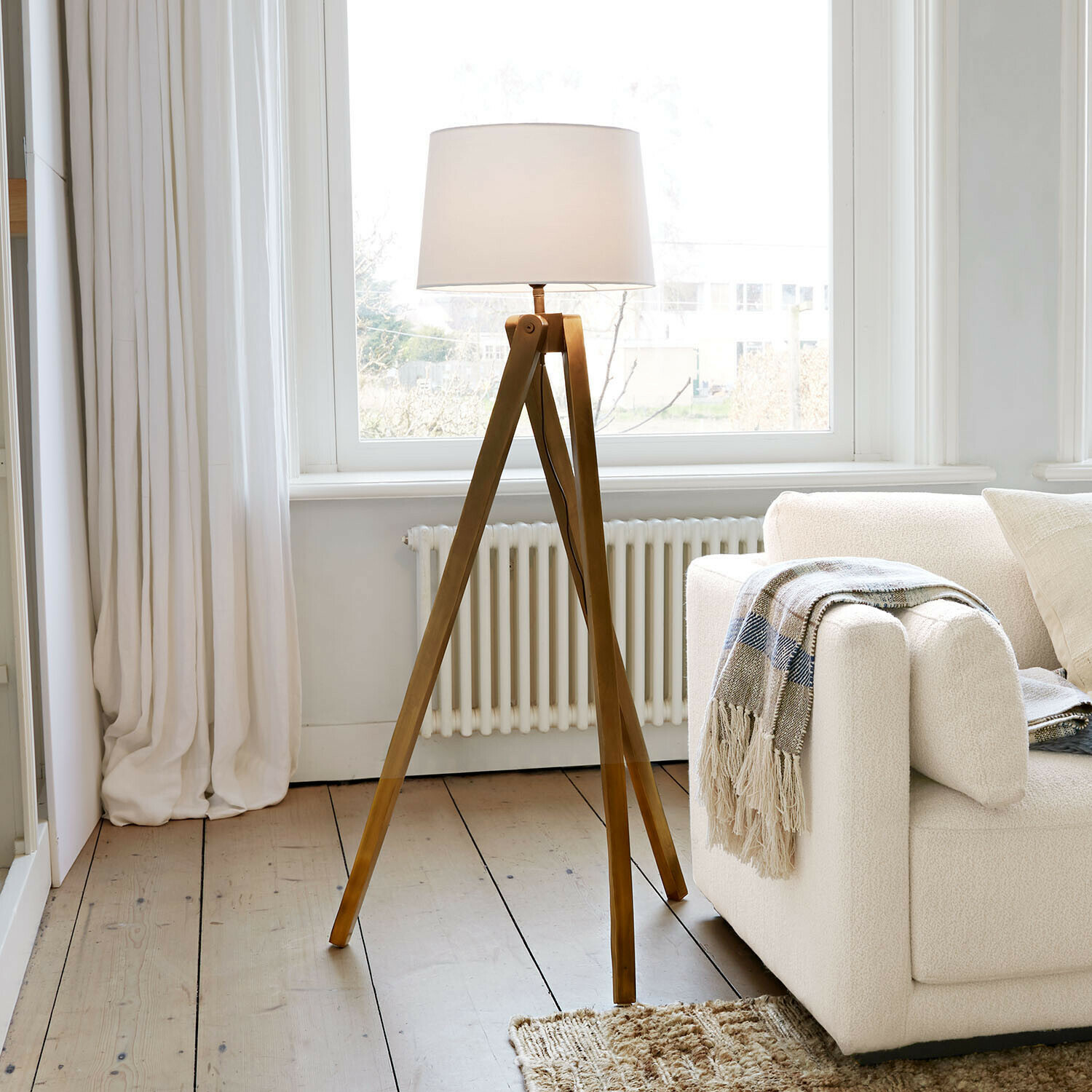 Vloerlamp Kelvio Vloerlamp met houten standaard en witte kap in lichte woonkamer met beige bank