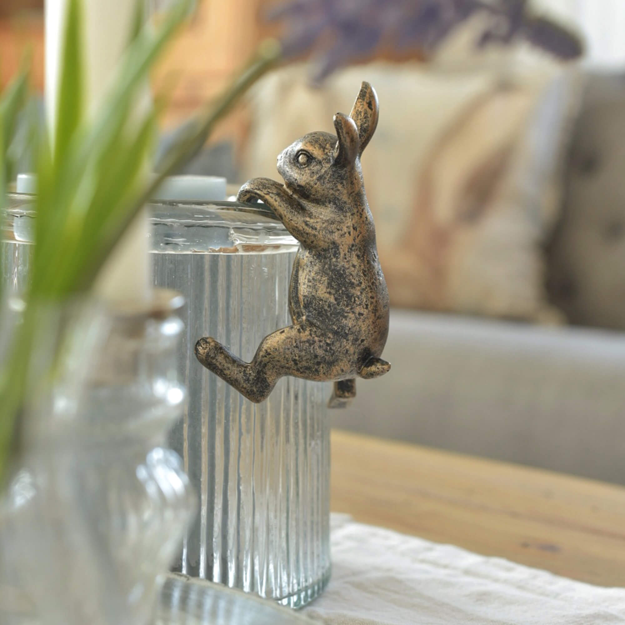 Decoratief metalen konijn in antiek goud aan glazen pot voor paasdecoratie