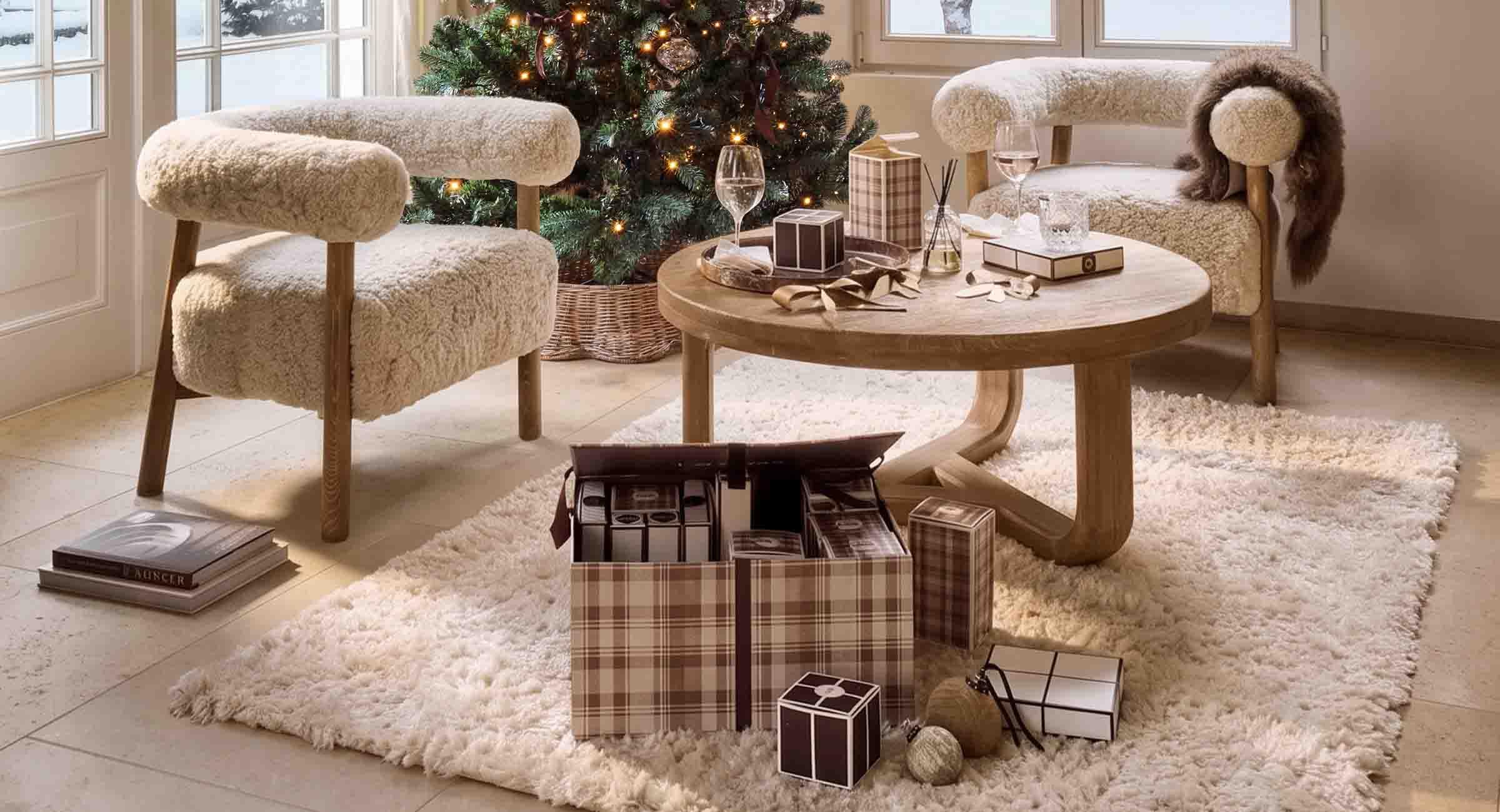 Gezellige woonkamer met crèmekleurige faux fur stoelen en houten tafel bij versierde kerstboom