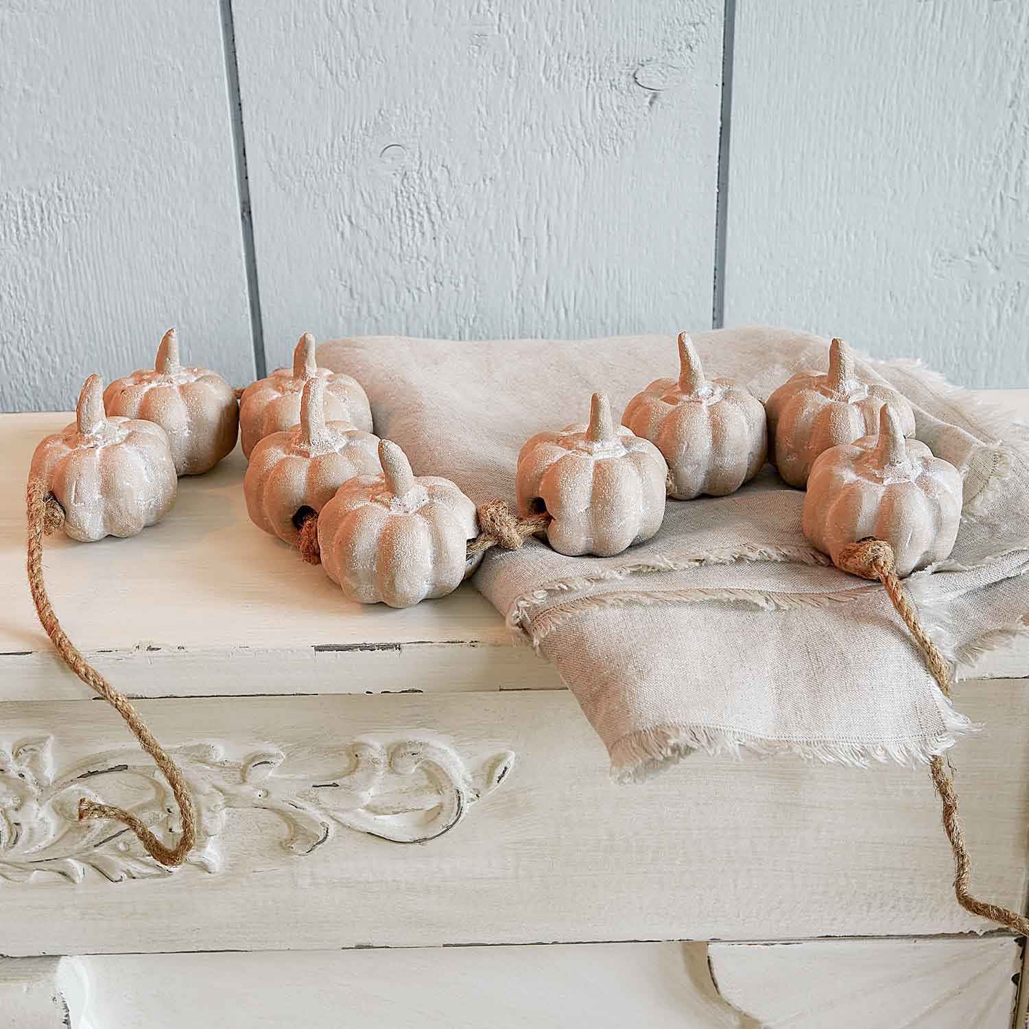 Decoratieve slinger van beige keramische pompoenen aan touw voor herfstdecoratie