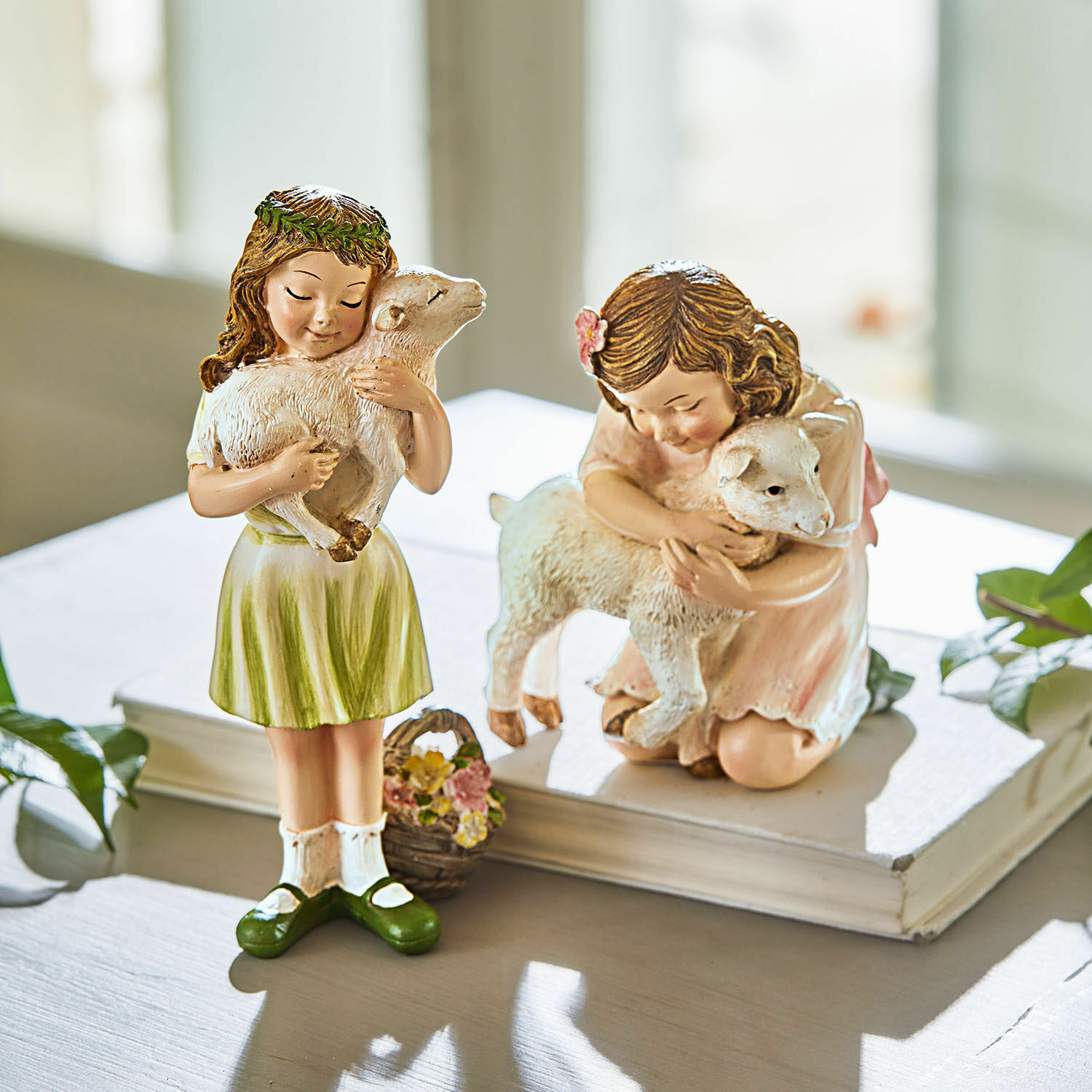 Beeldje set van 2 Clarisse Beeldjes van meisjes met lammetjes in pastelkleurige jurken op witte tafel, interieurdecoratie.