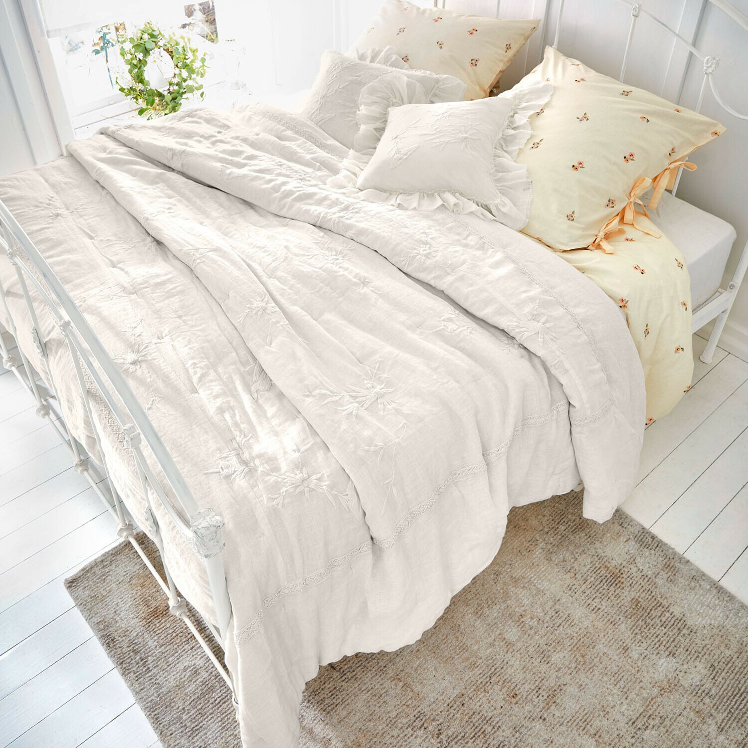 Quilt Norwyn Crèmekleurig linnen beddengoed met geborduurde bloemen en sierkussens, gezellige slaapkamerinrichting