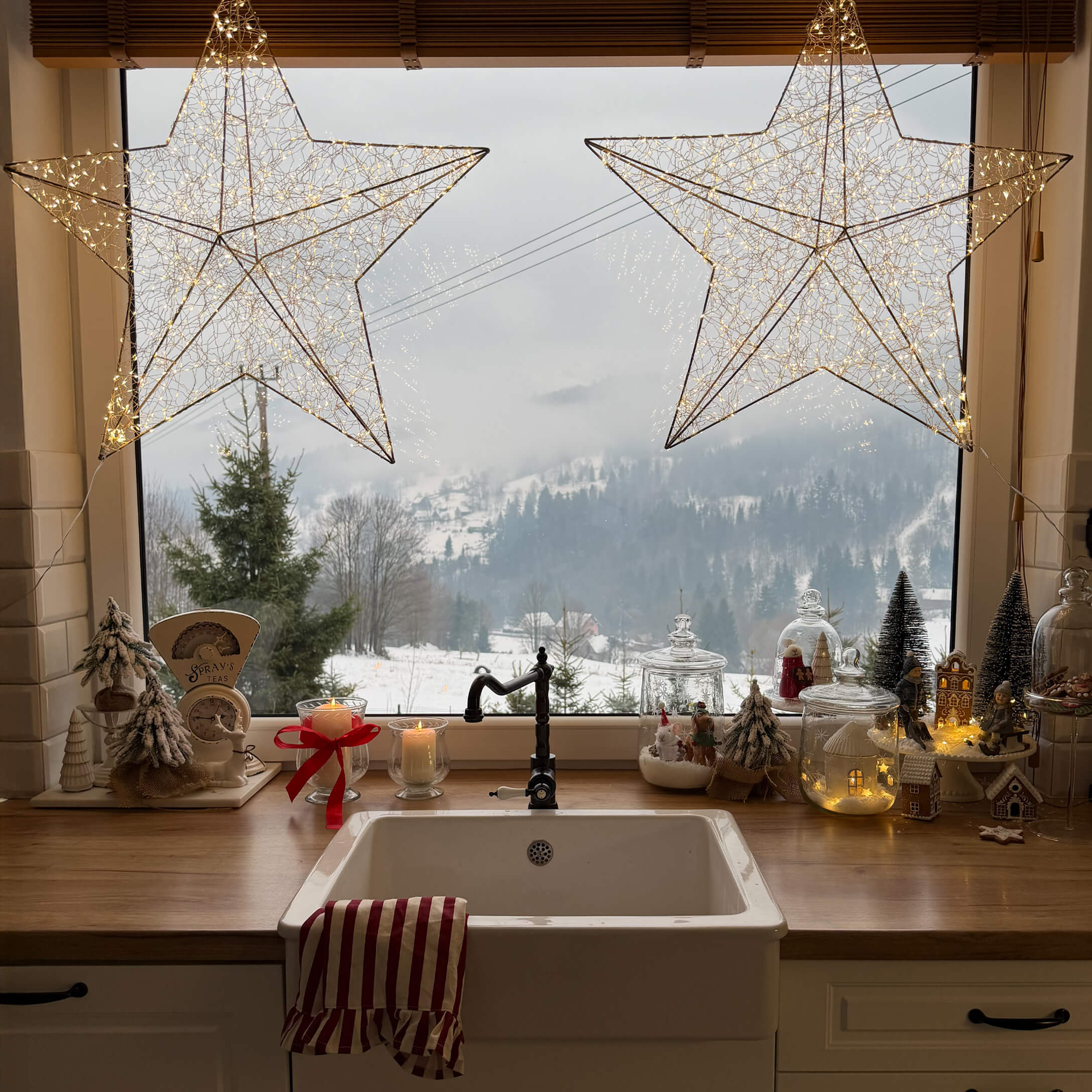 Keuken met witte gootsteen, houten werkblad, kerstdecoraties en uitzicht op winterlandschap