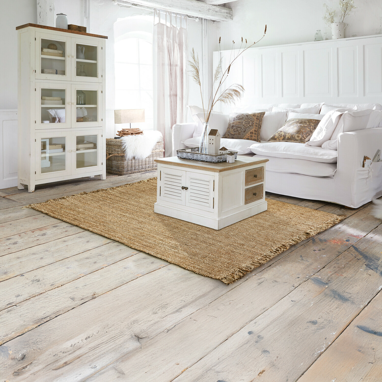 Rustieke woonkamer met witte houten kast en salontafel op natuurlijke jute vloerkleed