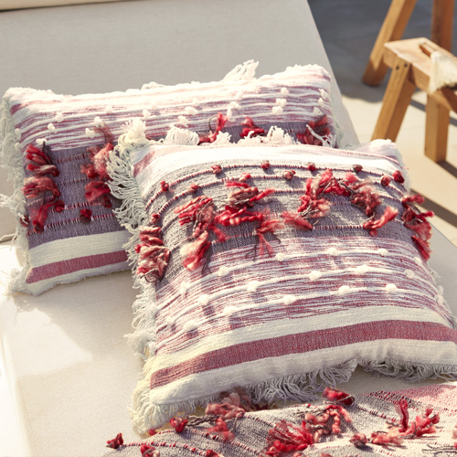 Decoratieve katoenen kussens met rood-witte strepen en franjes, perfect voor woonkamer en tuin