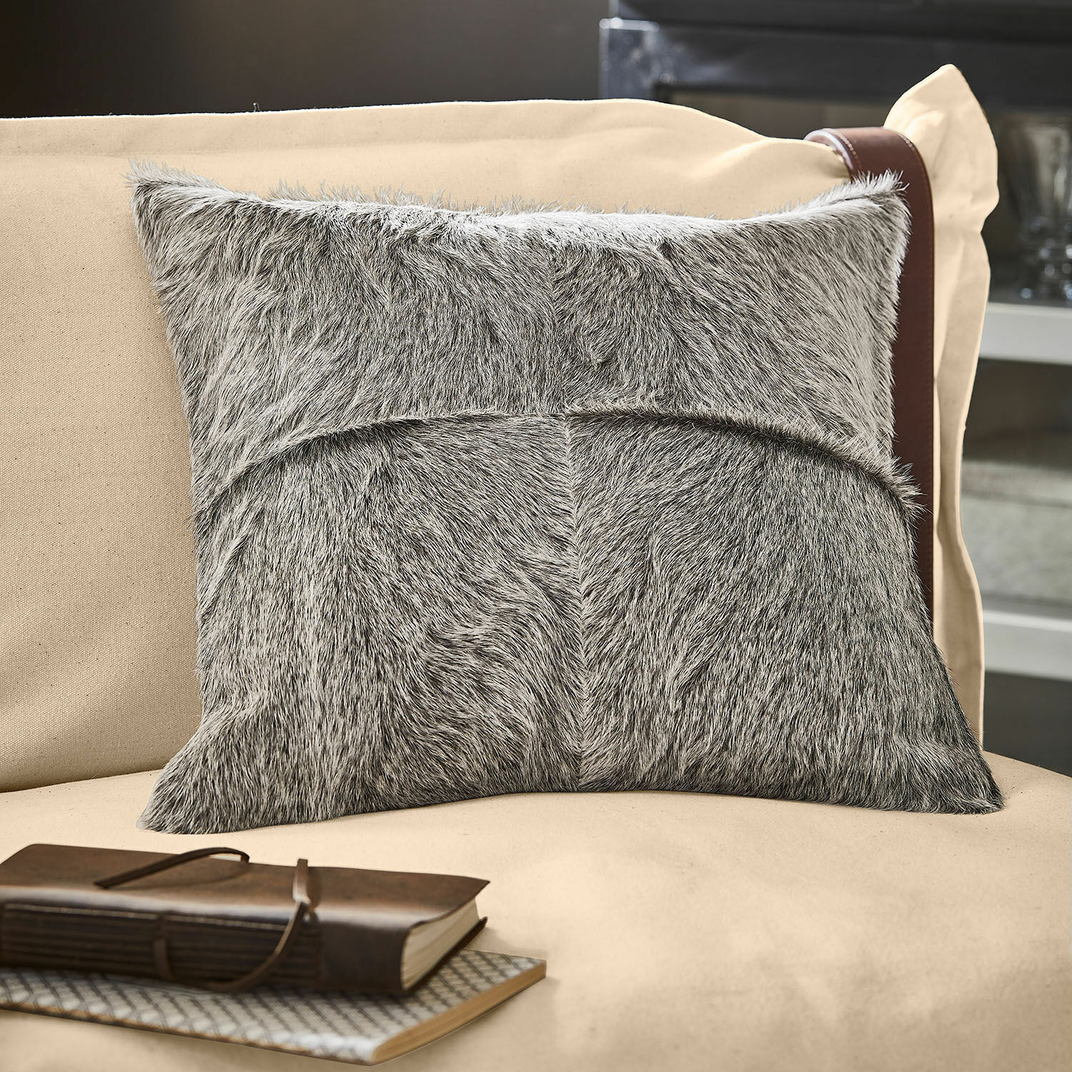 Kussenhoes Nymarion Grijs decoratief kussen van bontmateriaal op beige bank, stijlvolle woonaccessoire voor sfeer