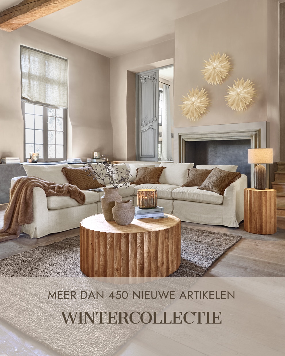 Gezellige woonkamer met beige bank, houten tafel en wanddecoraties uit de wintercollectie