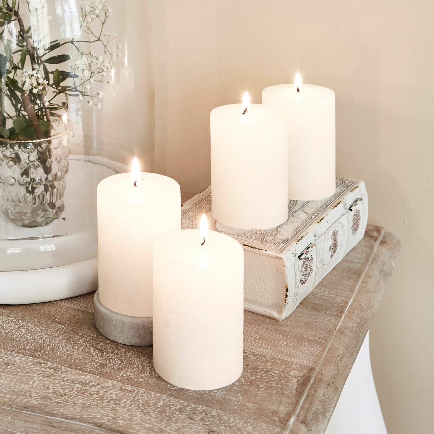 Kaars set van 4 Virrans Vier witte decoratieve kaarsen op houten blad met versierd boek en glazen vaas met bloemen