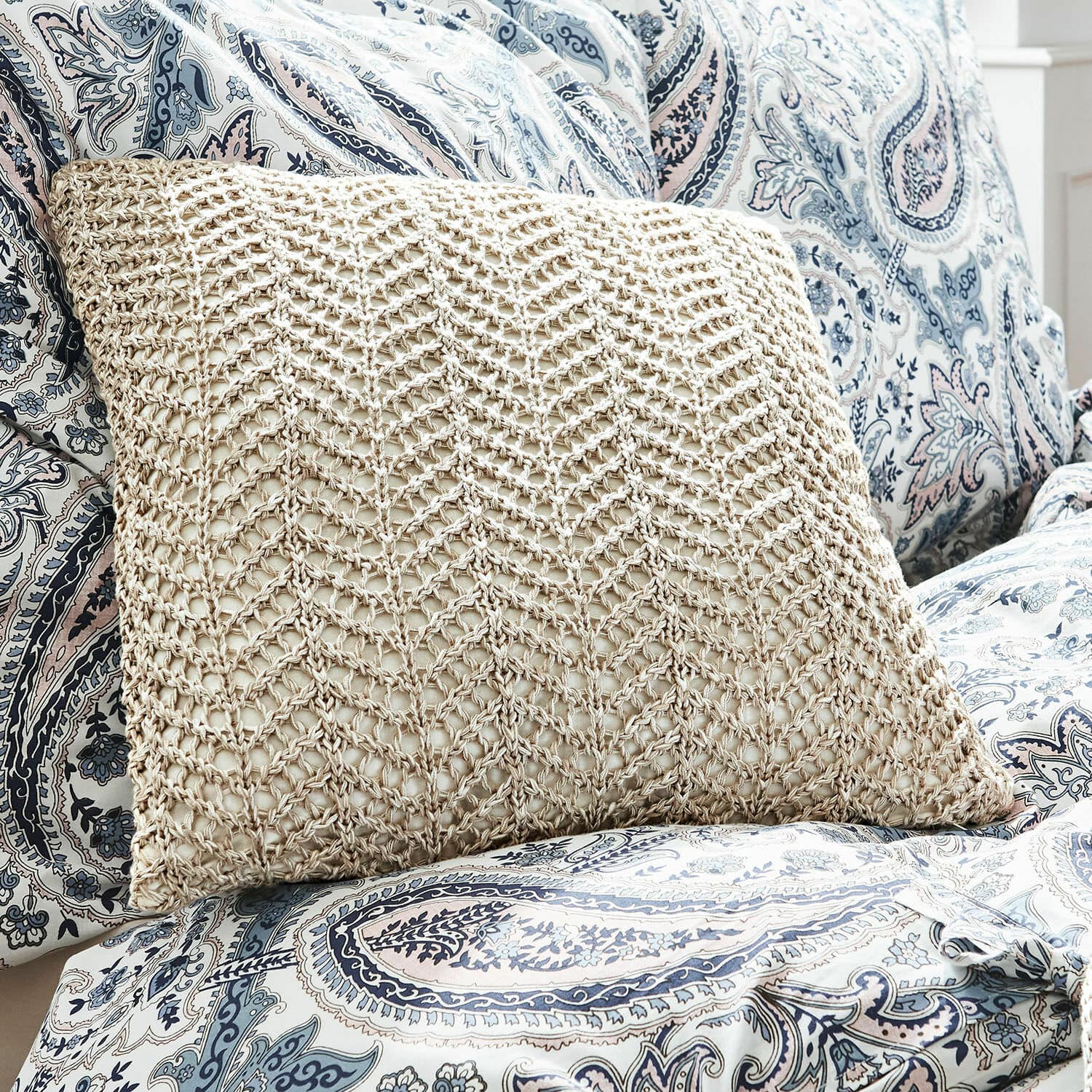 Kussenhoes Lukretia Beige kussen met gevlochten patroon op blauw-witte paisley hoes