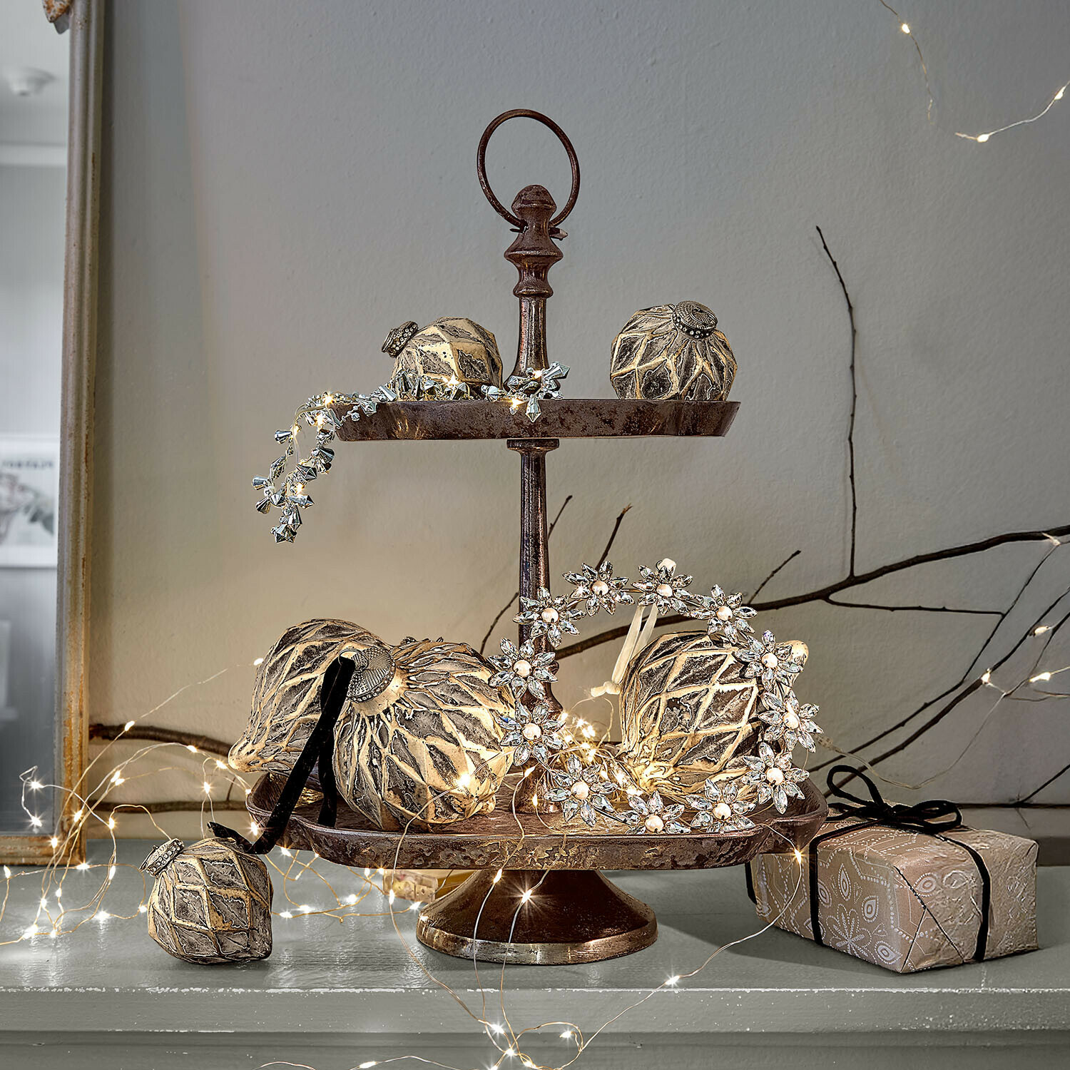 Tweeledig metalen etagère met gouden kerstversieringen en LED-lichtsnoer