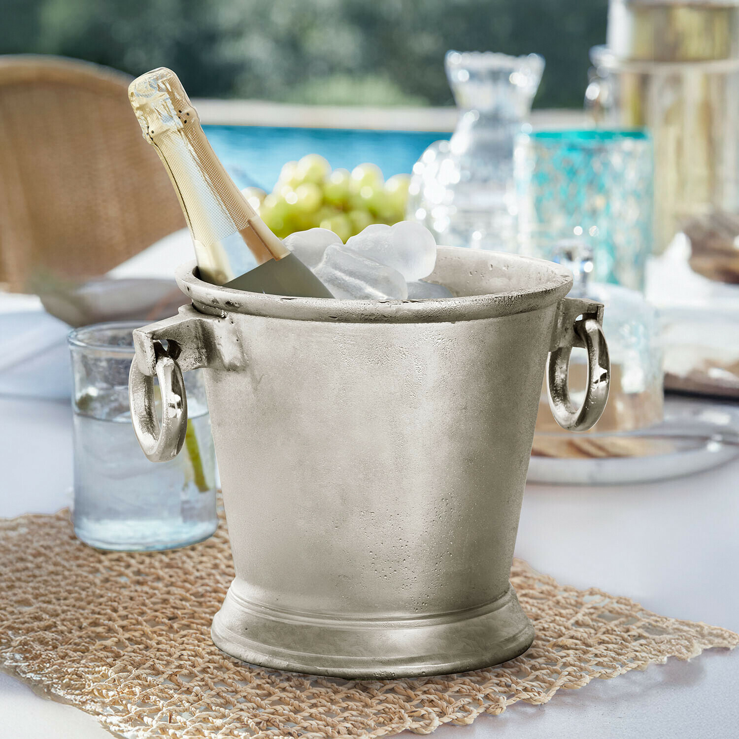 Drankenkoeler Cressford Zilverkleurige metalen ijsemmer met champagnefles en ijs op tuintafel
