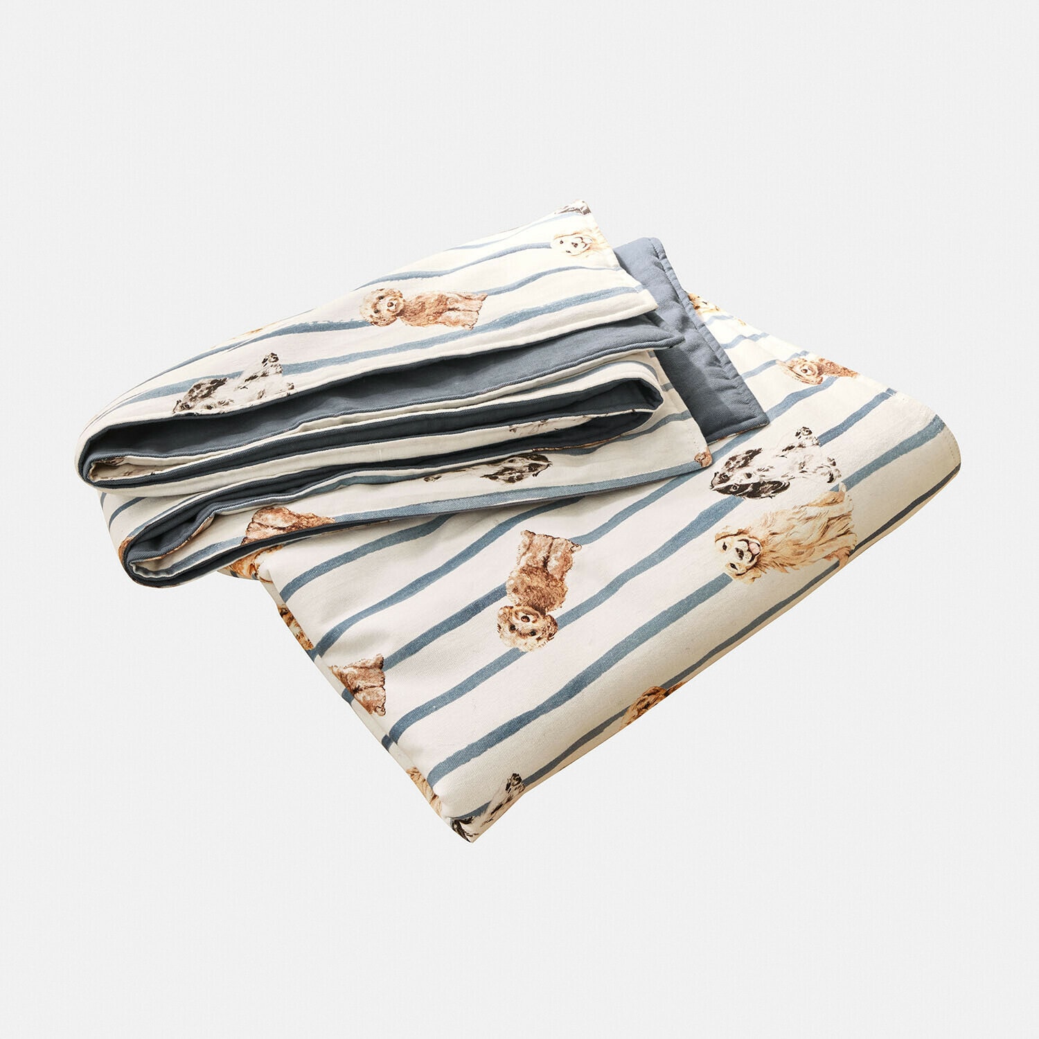 Opgevouwen katoenen plaid met blauwe strepen en beige hondenprint, slaapkamertextiel