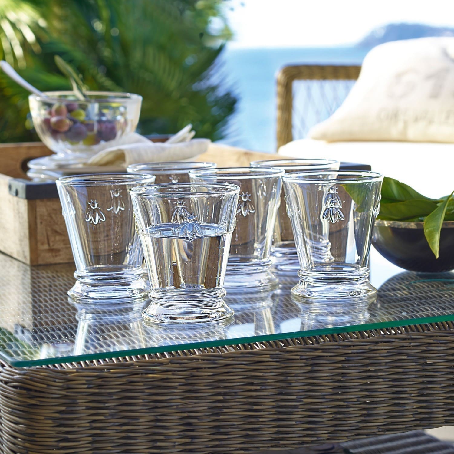 Waterglas set van 6 Abeille Set van zes heldere glazen met bijmotief op glazen tafel buiten