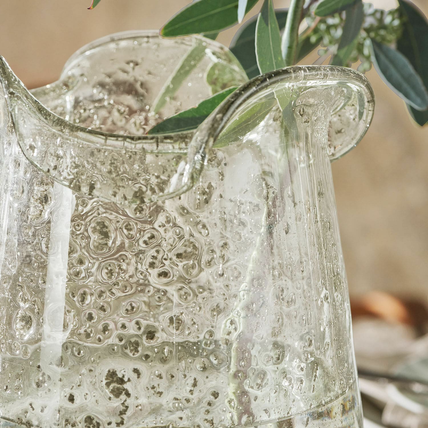 Transparante glazen vaas met bubbels en groene bladeren, decoratief kunstglas voor interieur