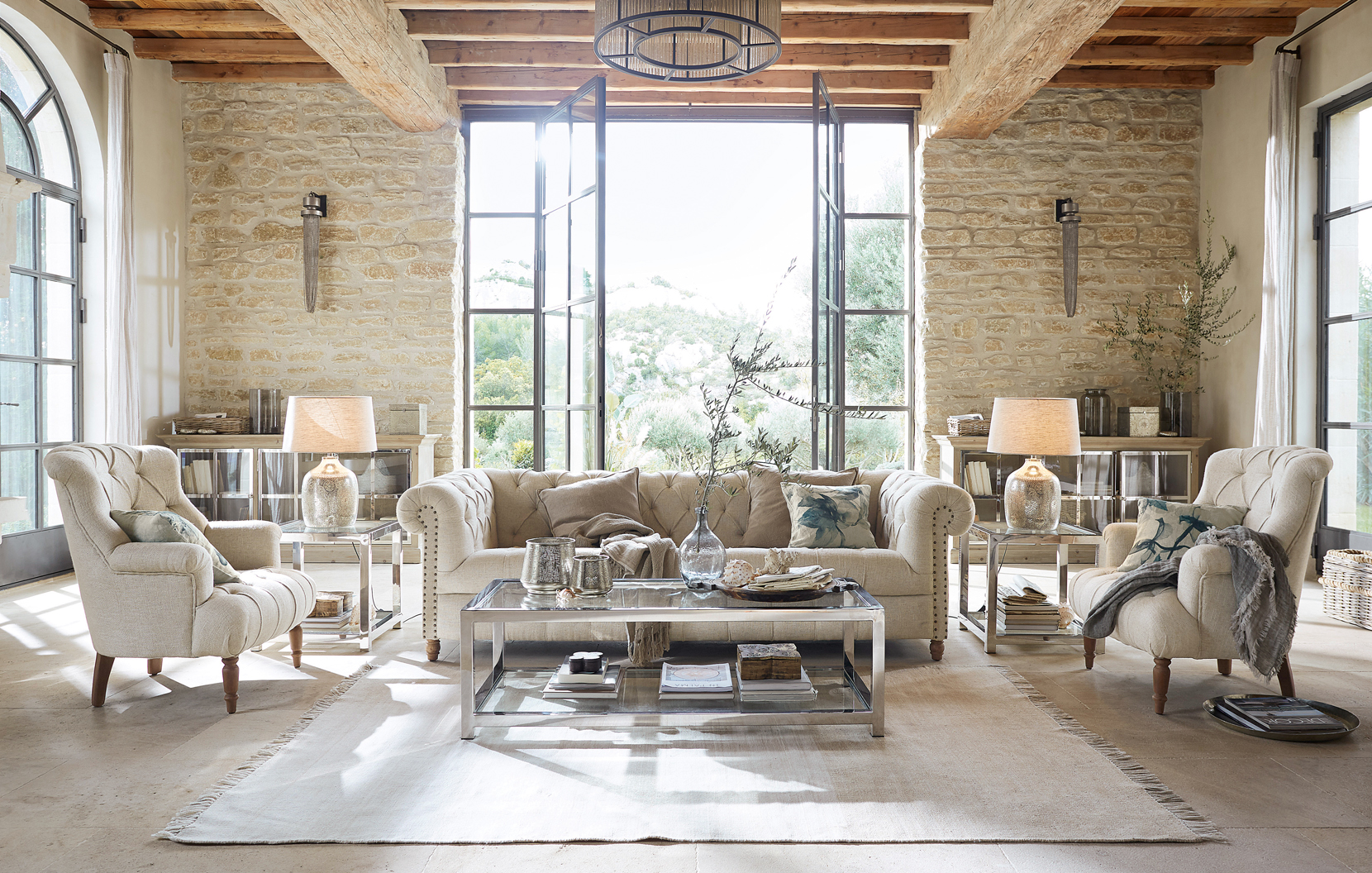 Klassiek elegante woonkamer met beige bank, fauteuils, glazen salontafel en natuurlijke materialen