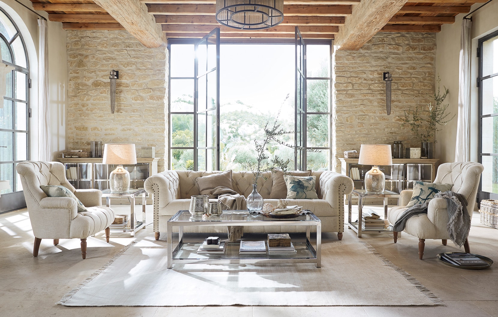 Klassiek elegante woonkamer met beige bank, fauteuils, glazen salontafel en natuurlijke materialen