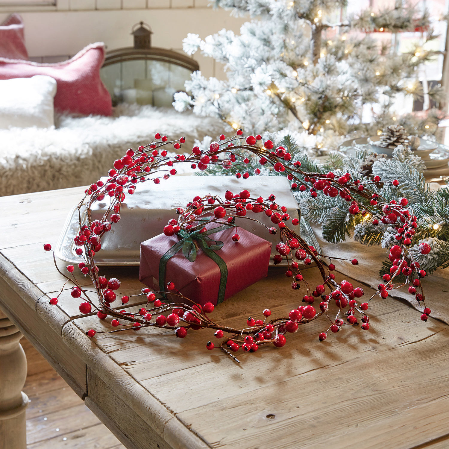 Guirlande Rimont Decoratieve krans van rode bessen op houten tafel met cadeau en kerstdecoratie