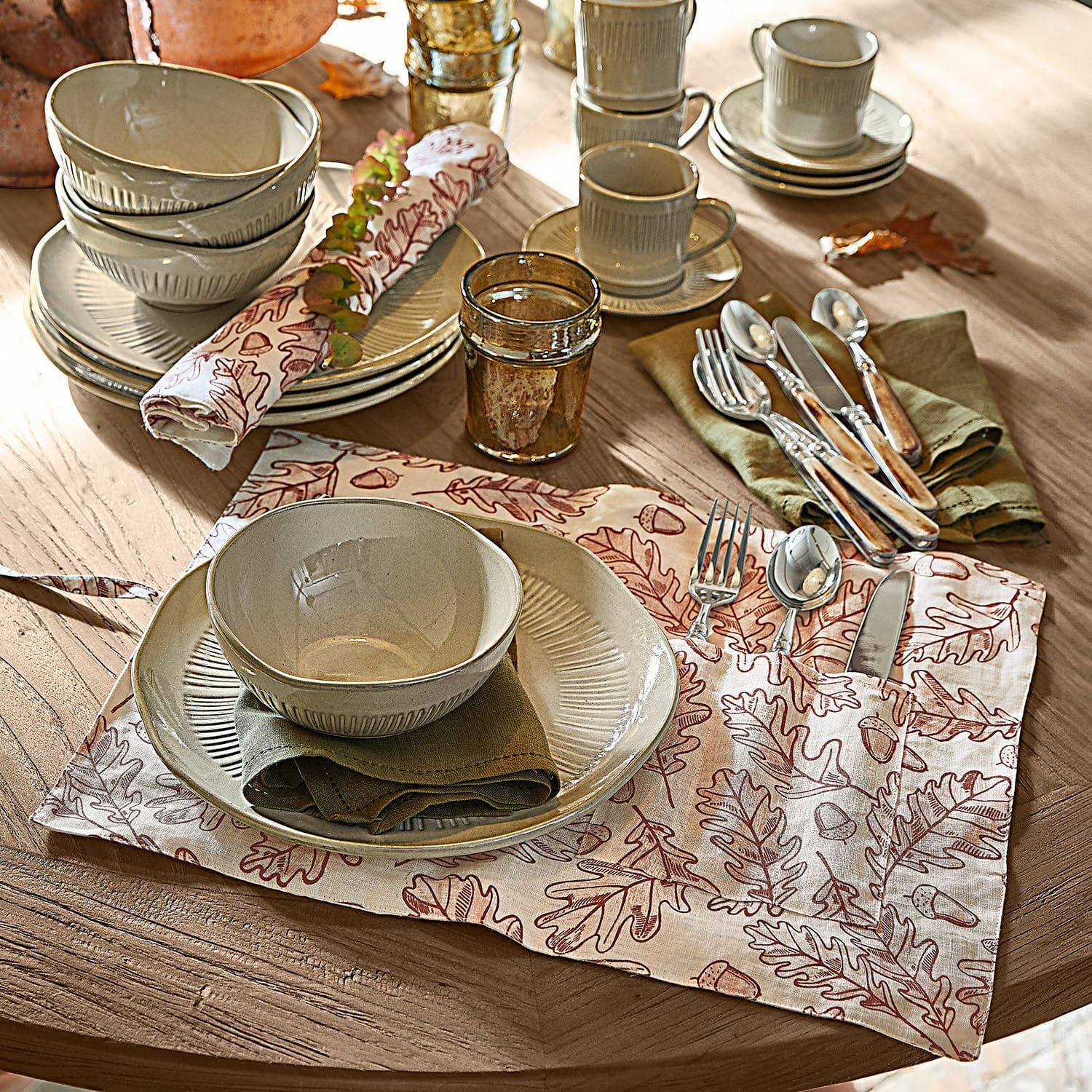 Placemat set van 2 Qubinal Beige keramisch servies met borden en kommen op houten tafel met decoratief servet met bladeren