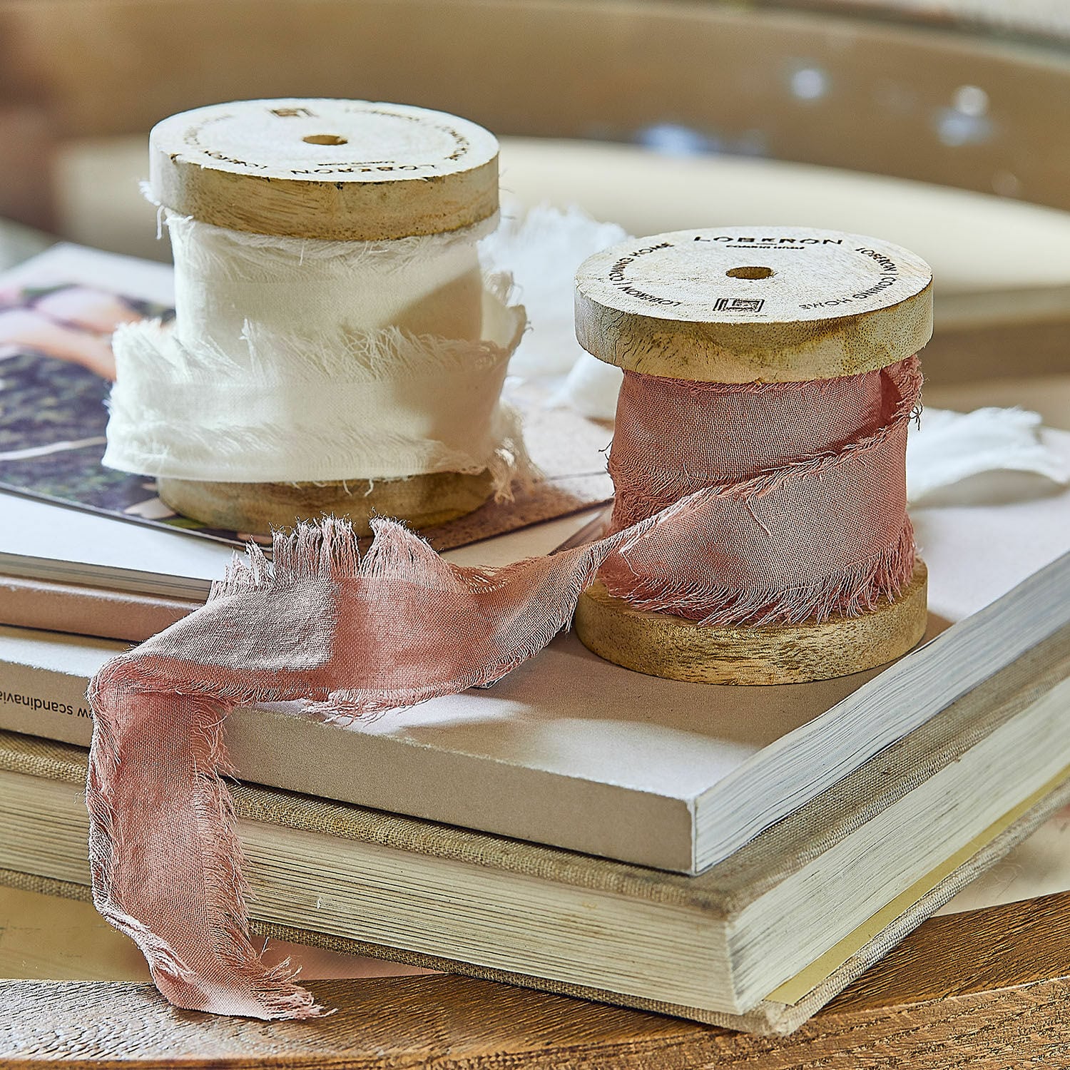 Lint set van 2 Valethor Houten spoelen met witte en roze katoenen lint op stapel boeken, sfeervolle woondecoratie