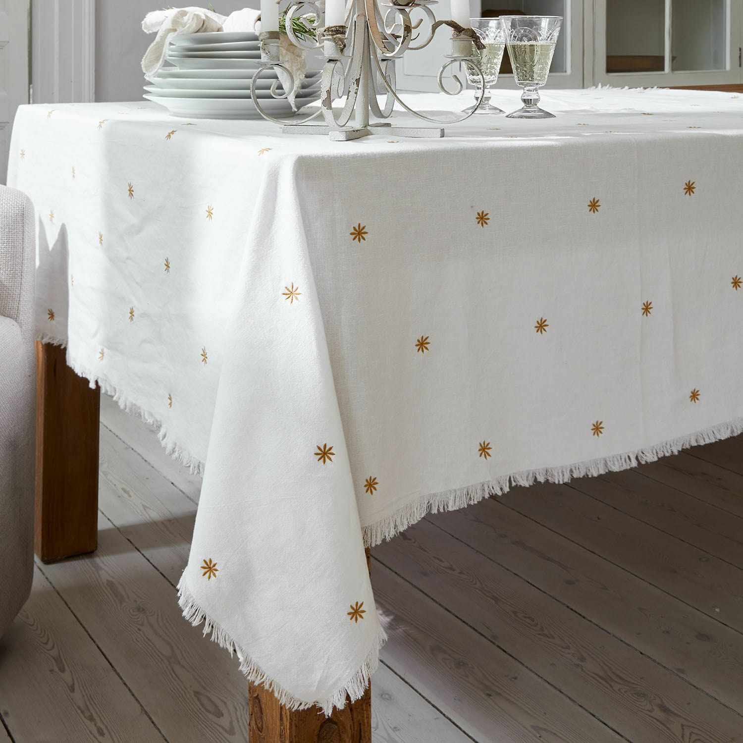 Witte linnen tafelkleed met franjes en gouden sterren, stijlvolle tafeldecoratie