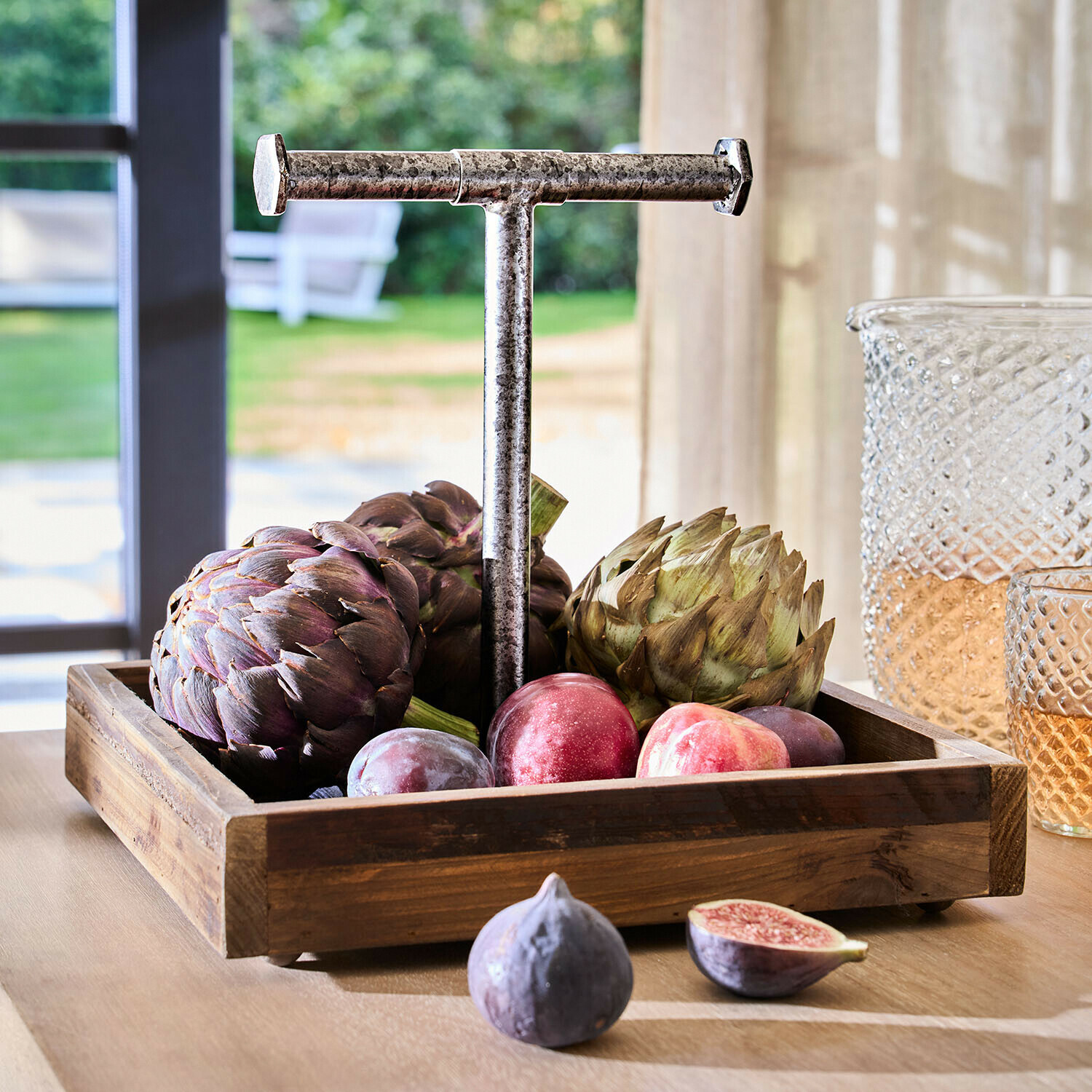 Dienblad Farrowby Houten dienblad met metalen handvat gevuld met artisjokken en pruimen op lichte tafel binnen