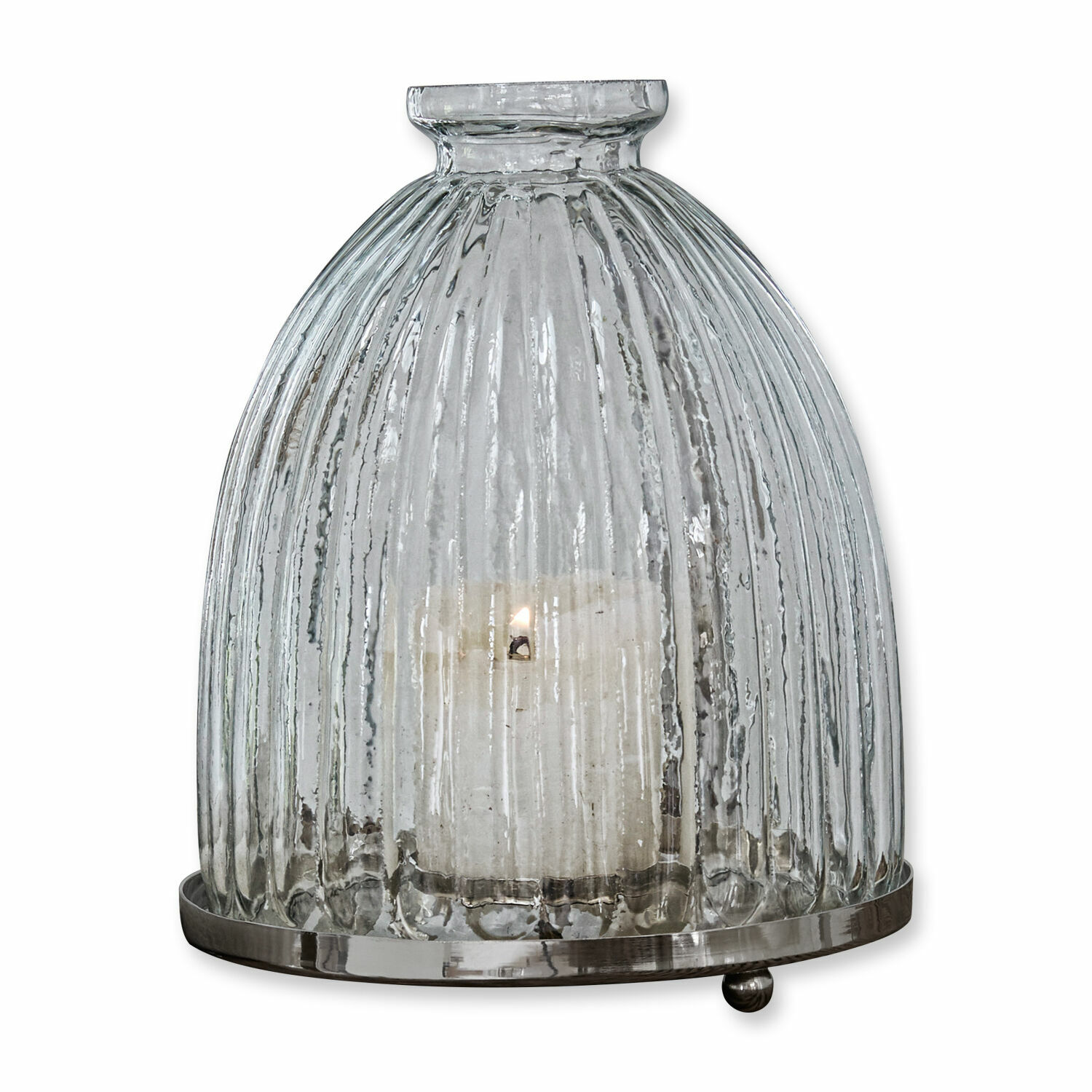 Lantaarn van doorzichtig geribbeld glas met metalen voet en brandende witte kaars binnenin