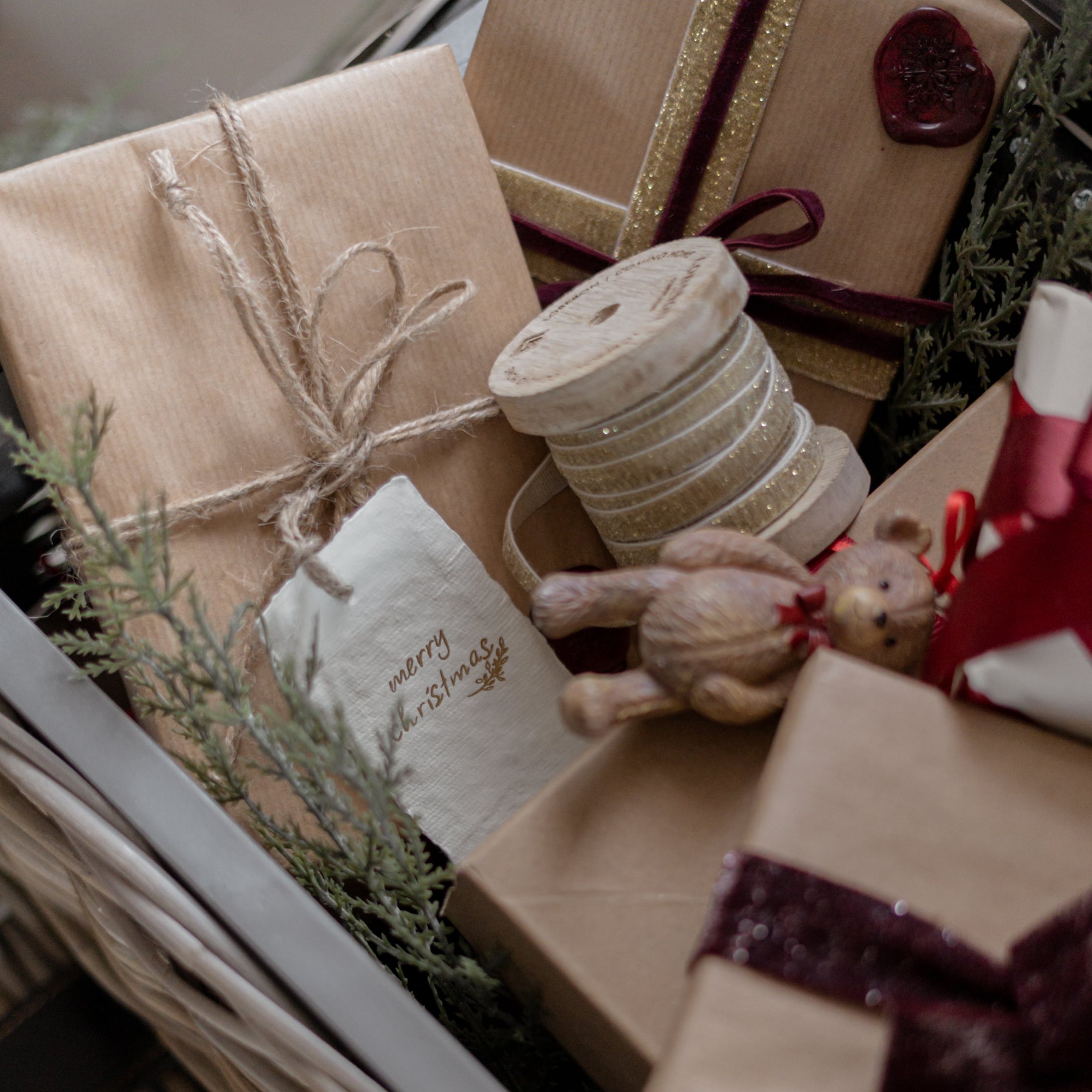 Kerstcadeaus verpakt in bruin papier met decoratief lint en klein houten beertje