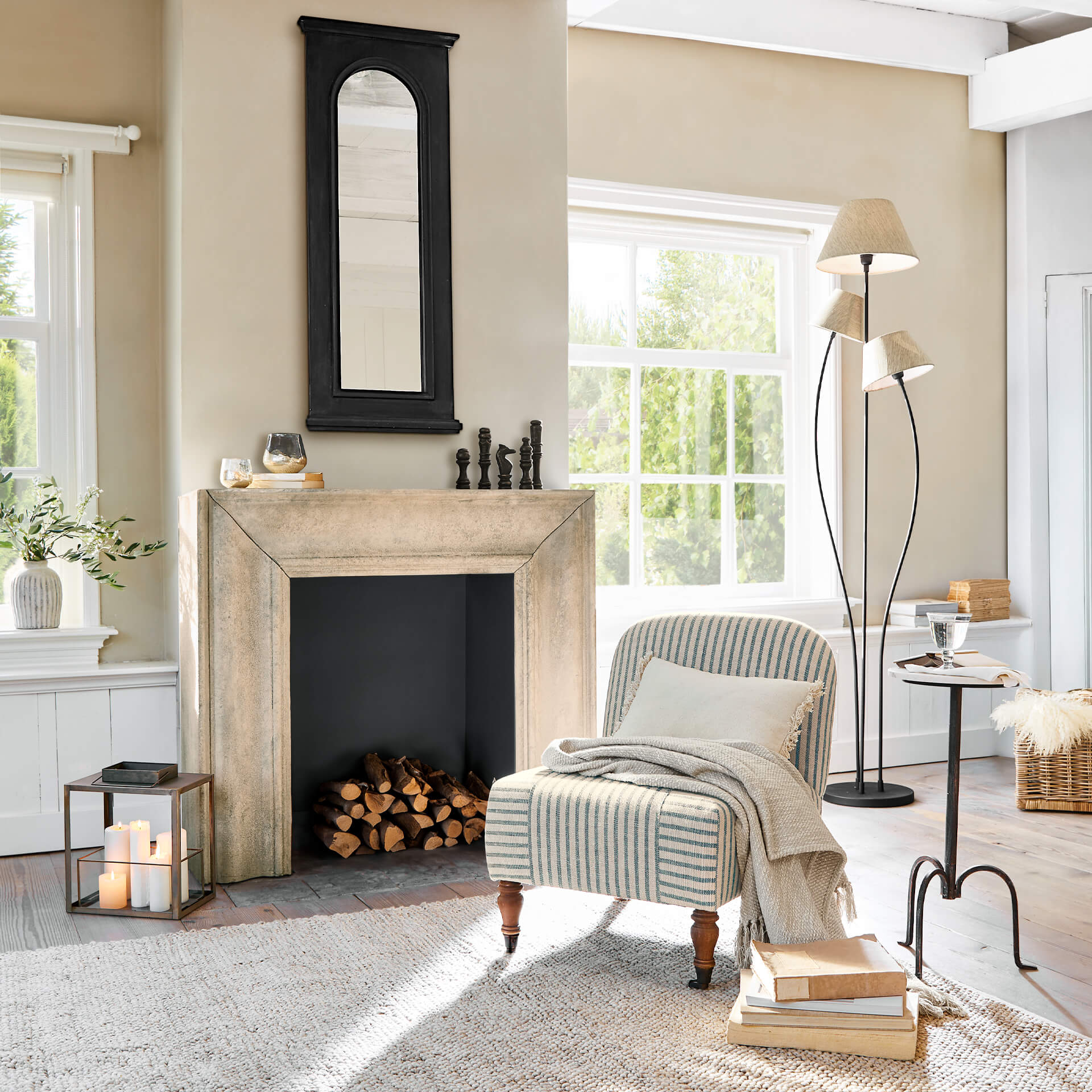 Gezellige woonkamer met beige open haard, zwarte spiegel en gestreepte vintage fauteuil
