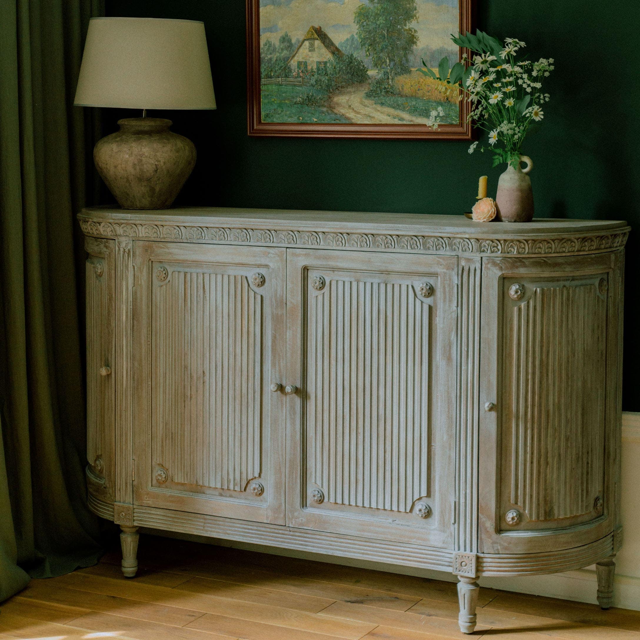 Lichte houten dressoir met gesneden details en bloemmotieven in een stijlvolle kamer