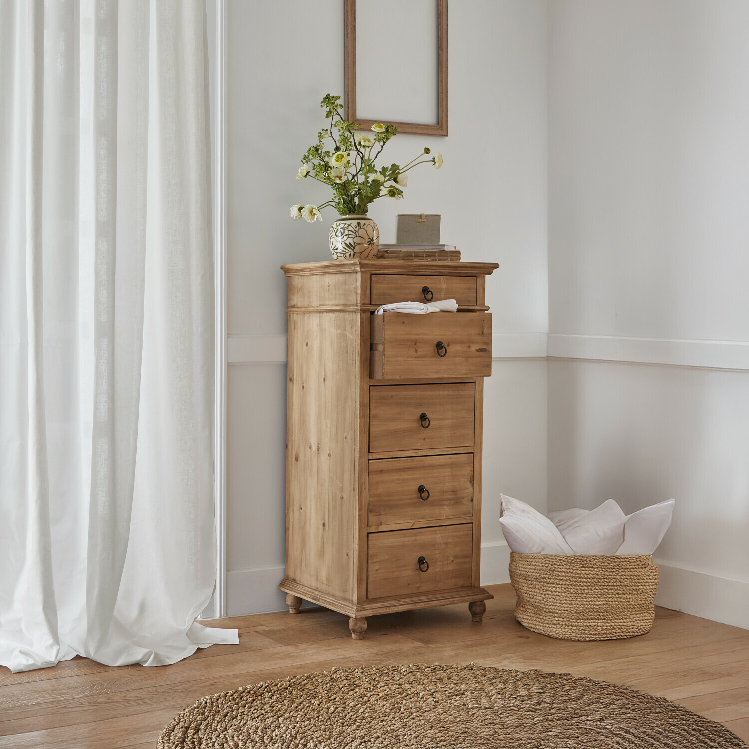 Ladekast Yewbridge Hoge kast van natuurlijk grenenhout met vier lades en decoratieve vaas met bloemen in lichte kamer