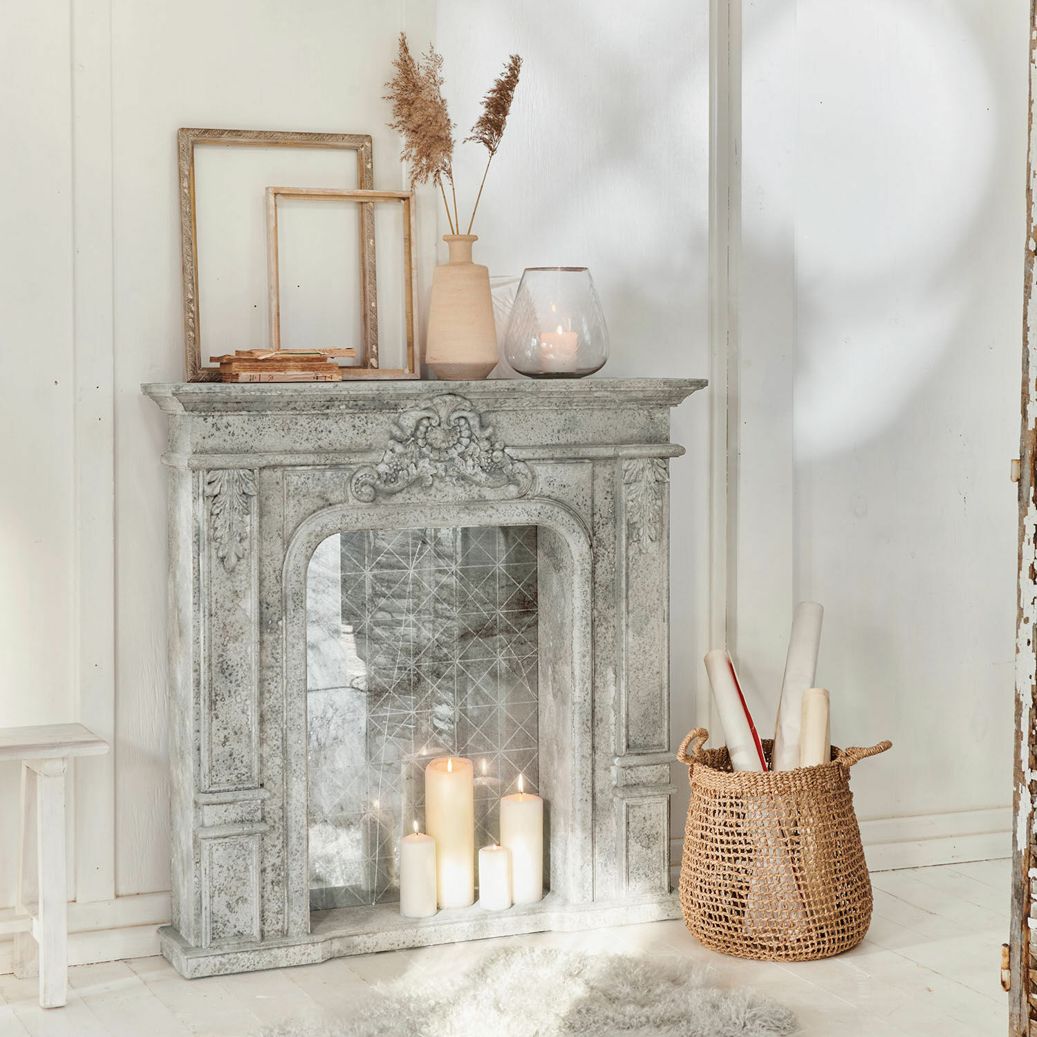 Haardschouw Rethonvillers Decoratieve grijze stenen schouw met brandende kaarsen en rieten mand op witte vloer
