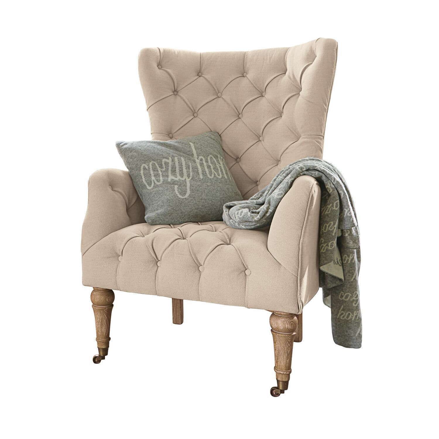 Fauteuil Migré Beige gestoffeerde fauteuil met houten poten, grijs kussen en cozy home deken