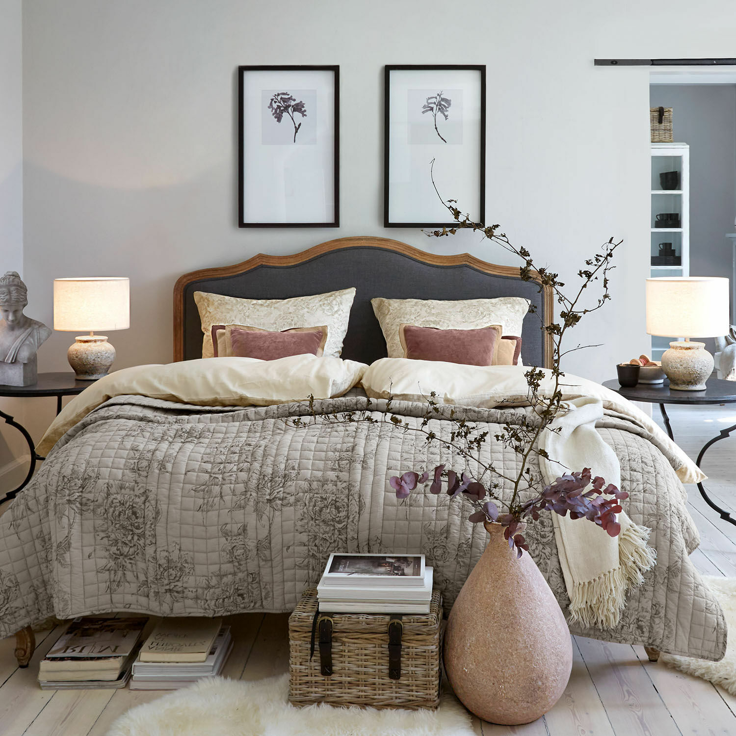 Beddengoed Bravonea Gezellige slaapkamer met houten bed en grijze bekleding, beige gewatteerde deken met bloemenpatroon, natuurlijke decoratie