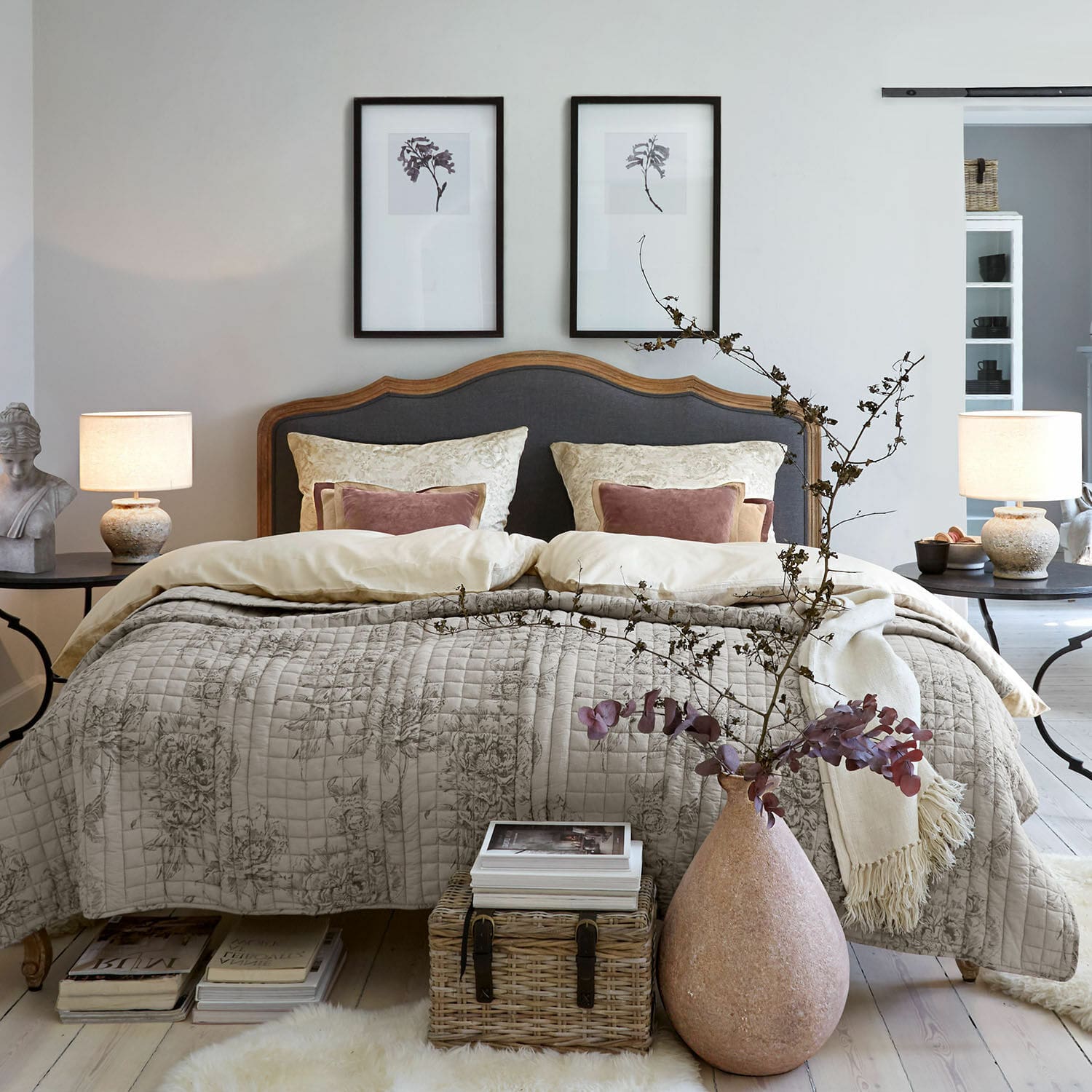 Beddengoed Bravonea Gezellige slaapkamer met houten bed en grijze bekleding, beige gewatteerde deken met bloemenpatroon, natuurlijke decoratie