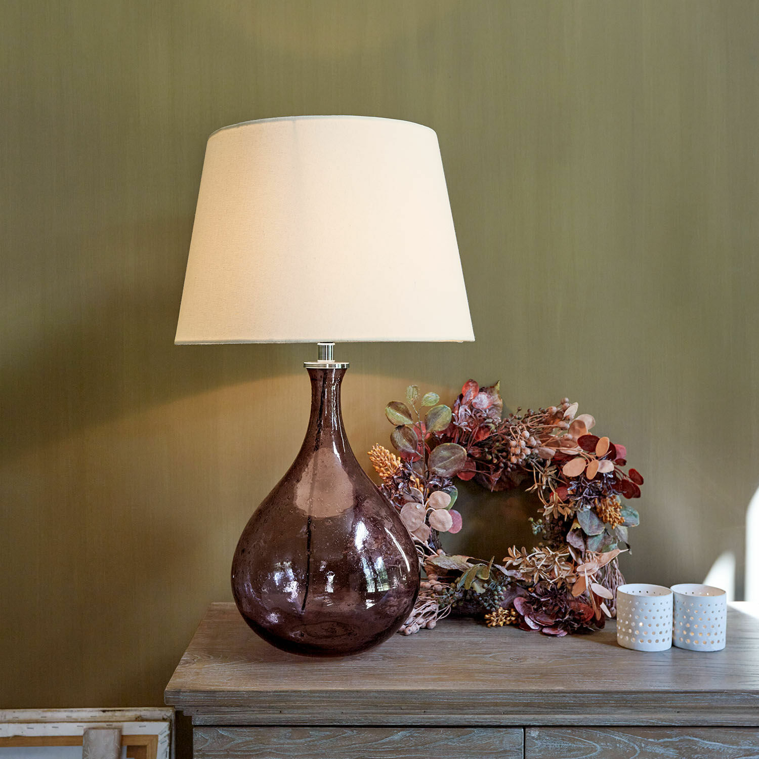 Tafellamp Calandor Tafellamp van paars glas met witte kap op houten tafel met herfstdecoratie