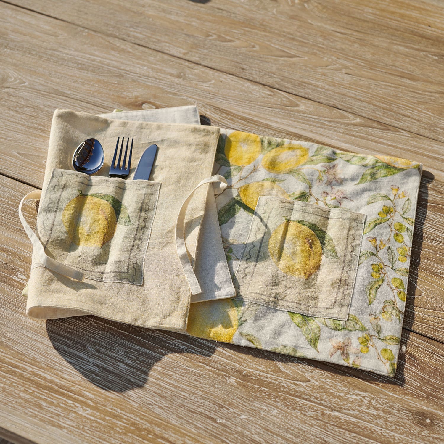 Placemat set van 2 Lantagenet Linnen bestekhoes met gele citroenprint en zakje op lichte houten tafel, praktische opbergoplossing
