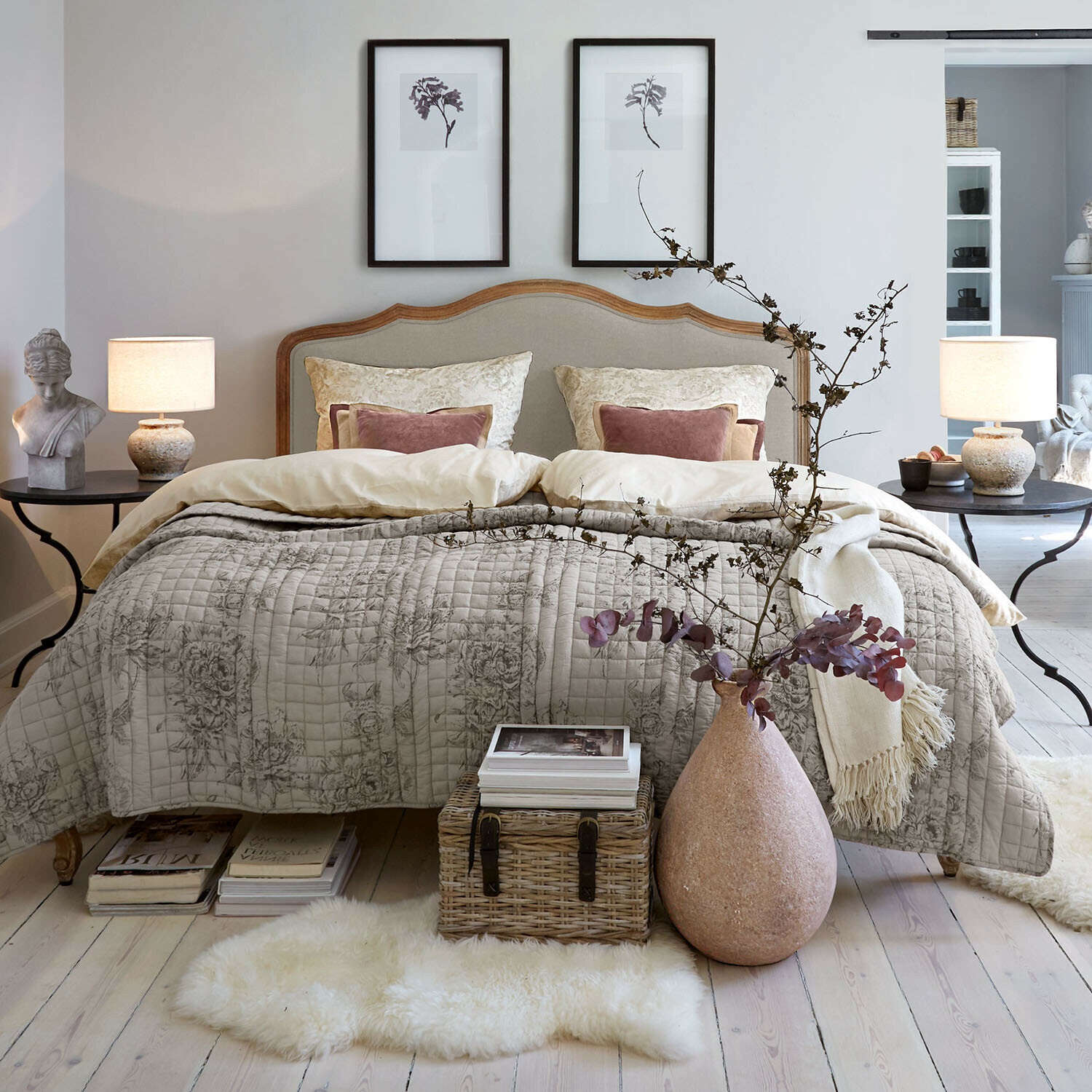 Bed Serravalle Gezellige slaapkamer met bed in beige beddengoed en decoratief doorgestikt bloemmotief dekbed