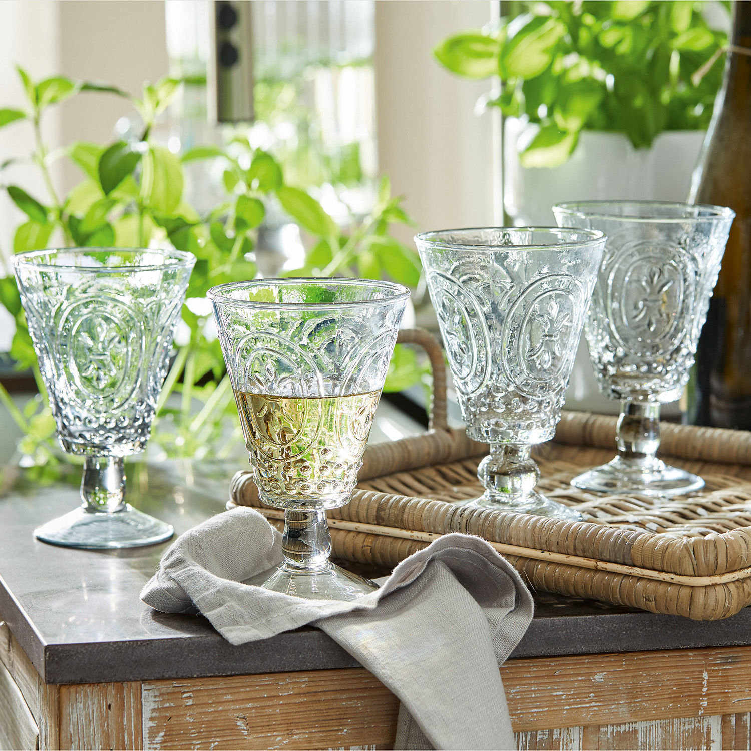 Wijnglas set van 4 Sarton Set van vier transparante glazen met decoratief patroon op een rotan dienblad op tafel