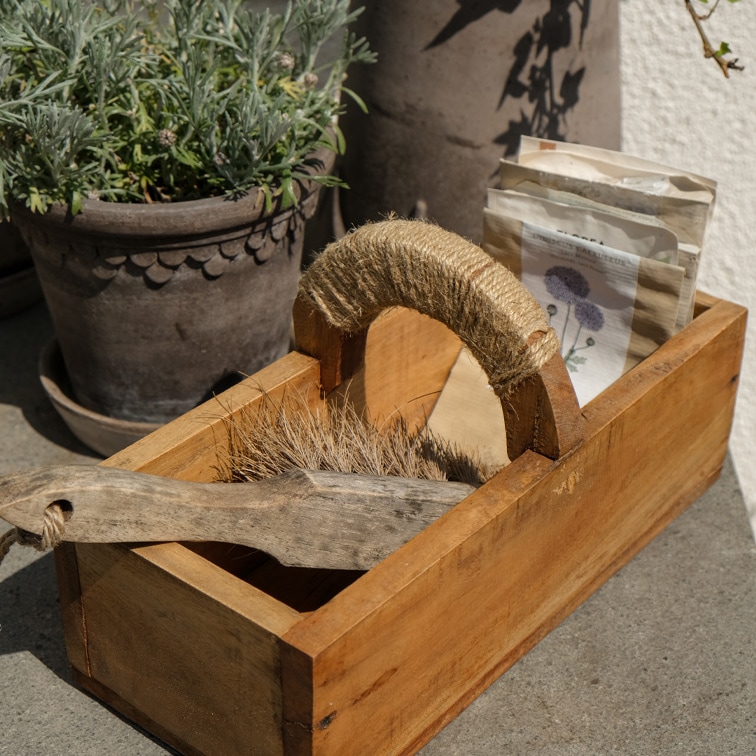 Houten doos met handvat omwikkeld met touw, bevat borstel en zaadzakjes, natuurlijke materialen